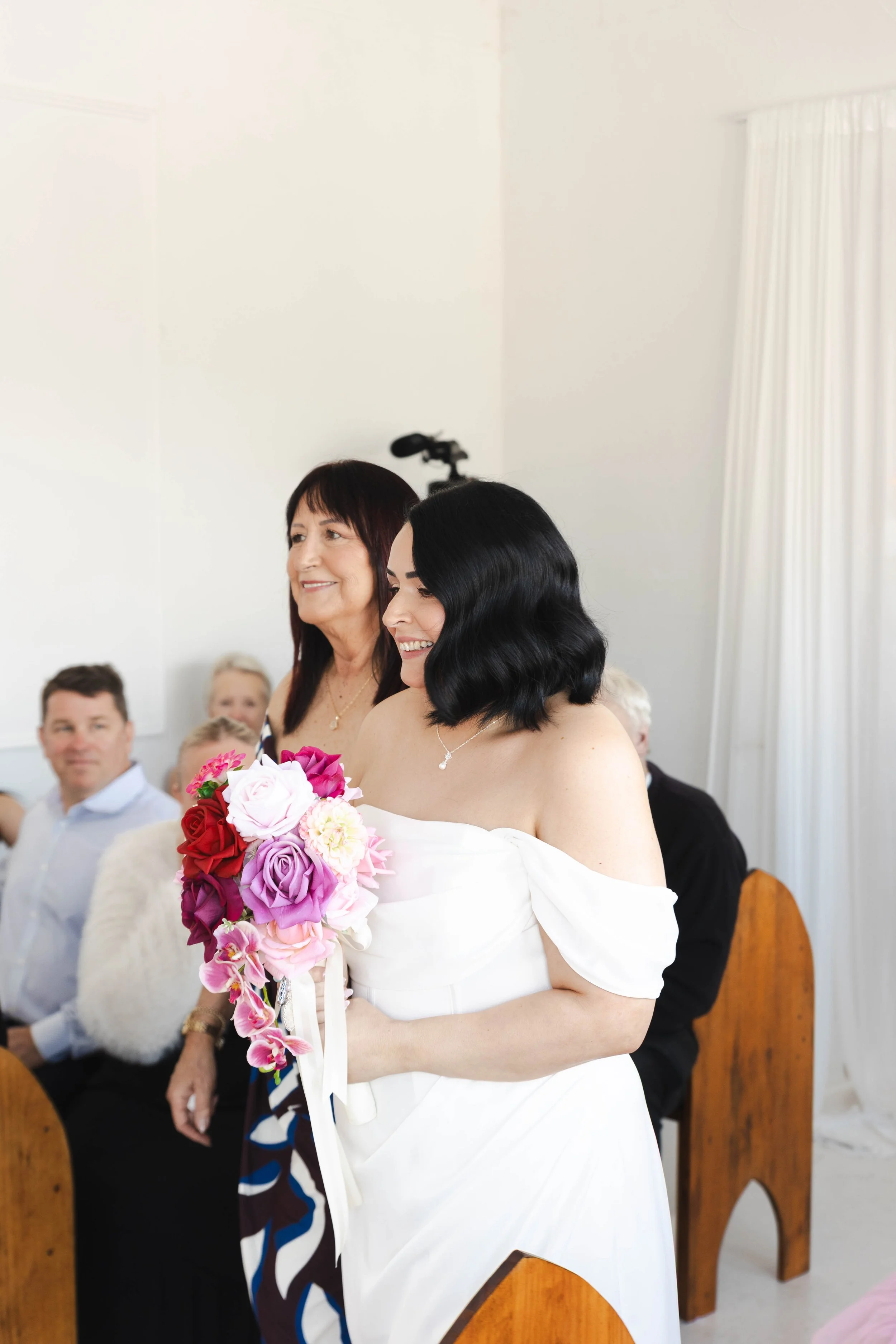 Shannon & Jarred's wedding at Faithwood Chapel – bride holding a bouquet of pink, red and purple flowers