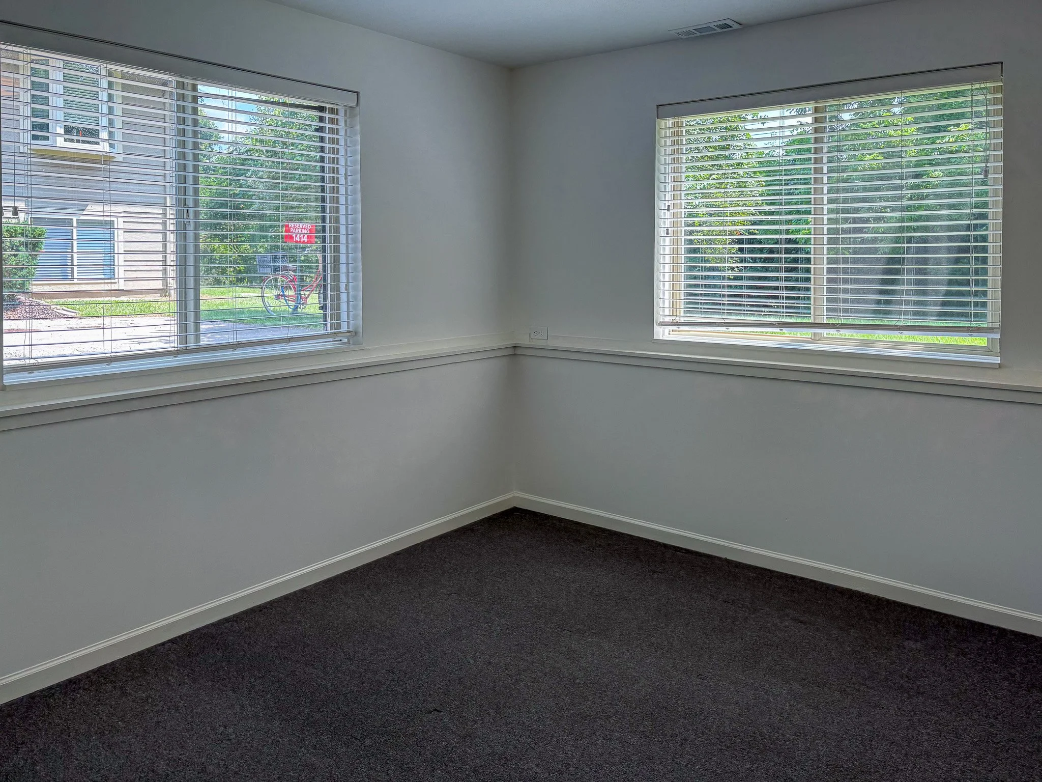 empty-bedroom-dark-carpet-two-windows.jpg