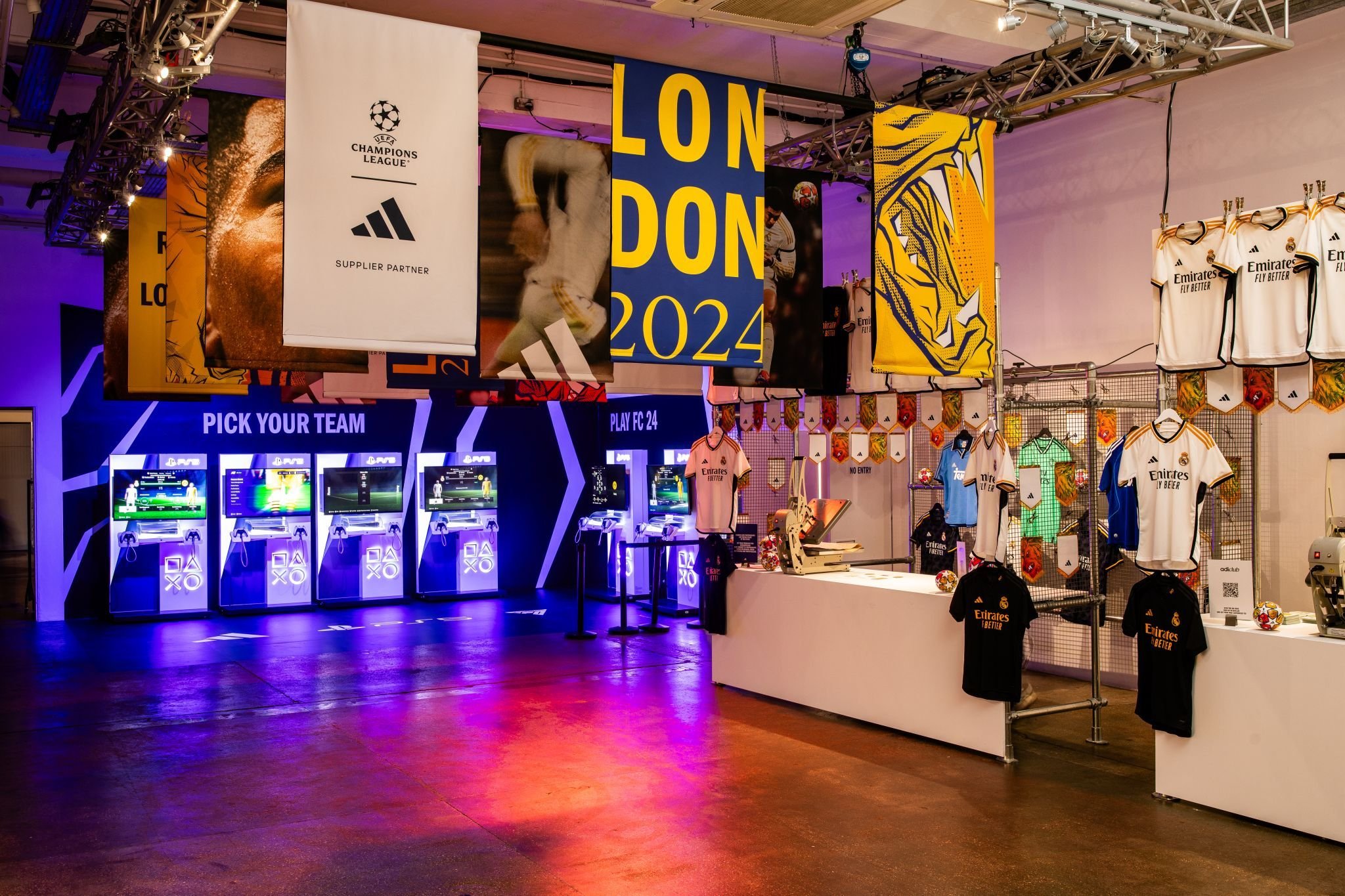 Football-themed merchandise and a locker room area with video game stations at a 2024 London event.
