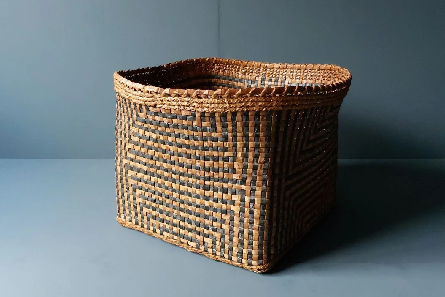 Large cedar bark basket with a circular design on the side
