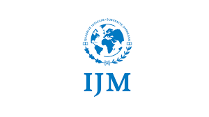 Logo featuring a globe and "IJM" lettering, surrounded by text in Cyrillic and laurel branches.
