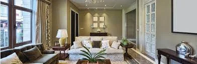 Living room with large windows, a sofa, a coffee table, and a decorative plant.