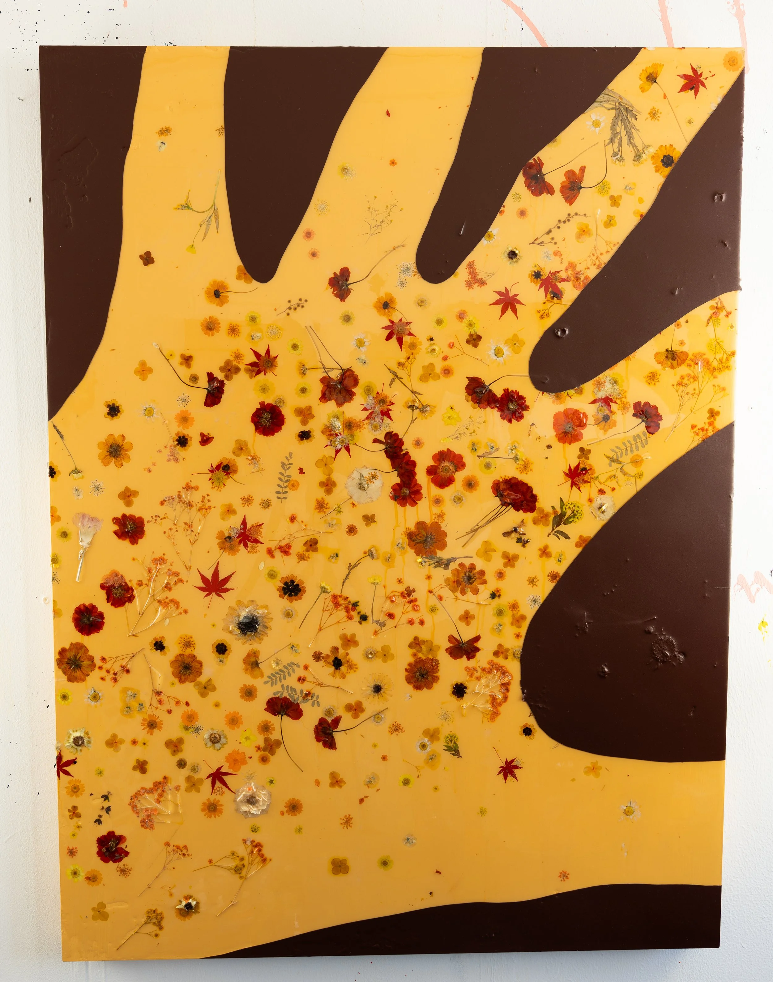 Pressed flowers embedded in resin with a spray painted stencil over the top