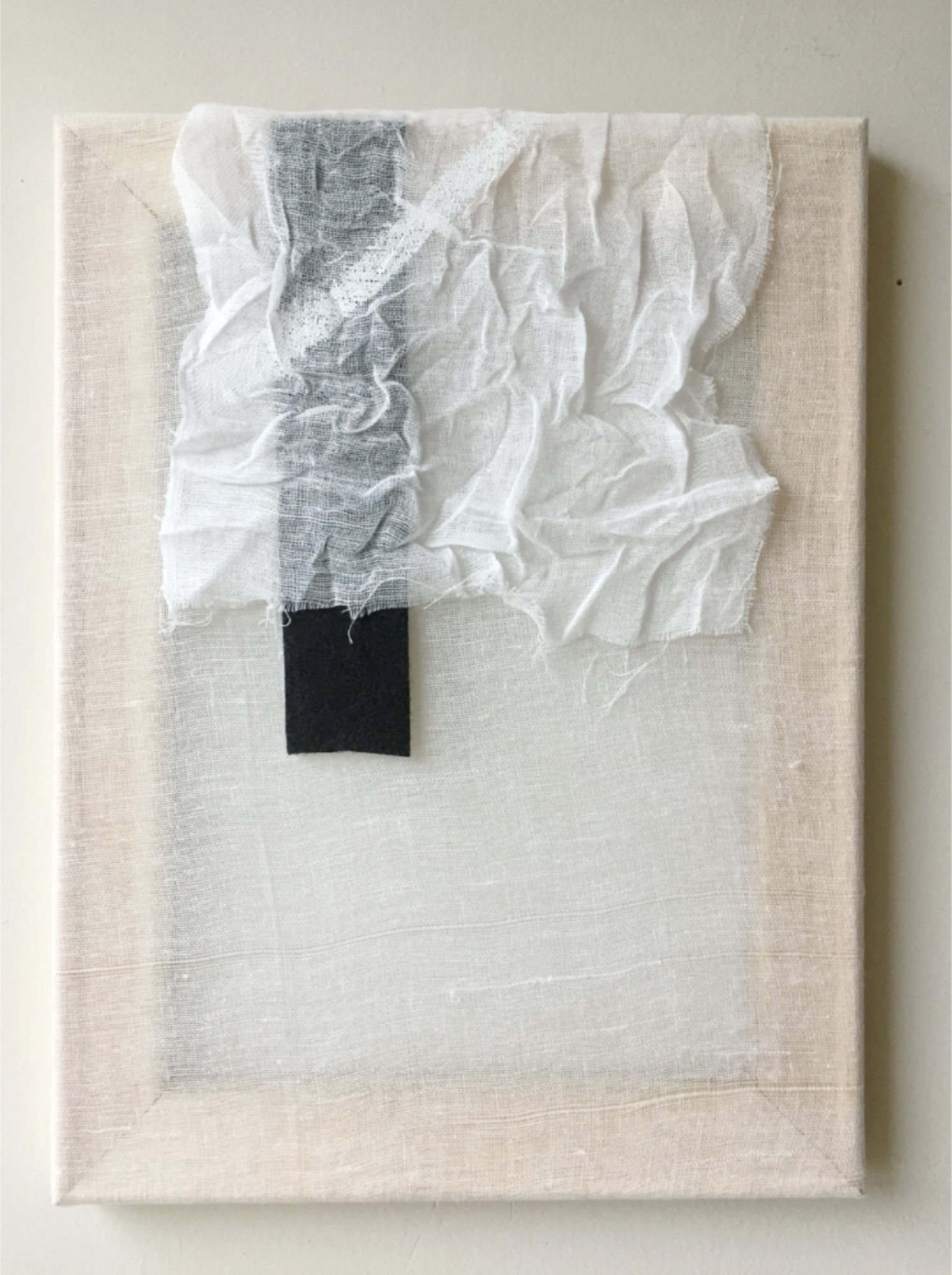 Minimal abstract composition with layered white fabric and a small black geometric element on a neutral ground