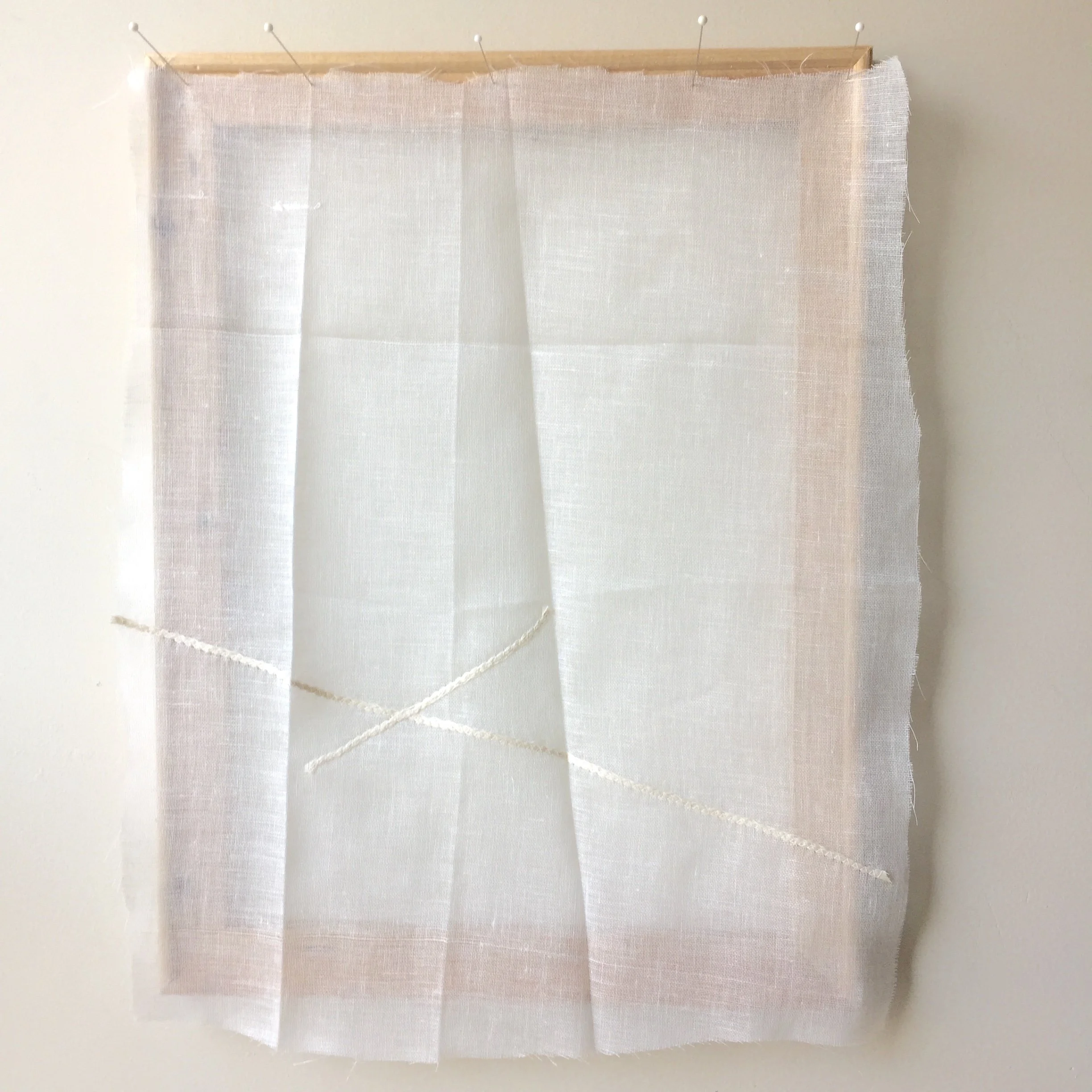 Minimal abstract textile artwork with sheer white fabric layered and stitched on a wooden support