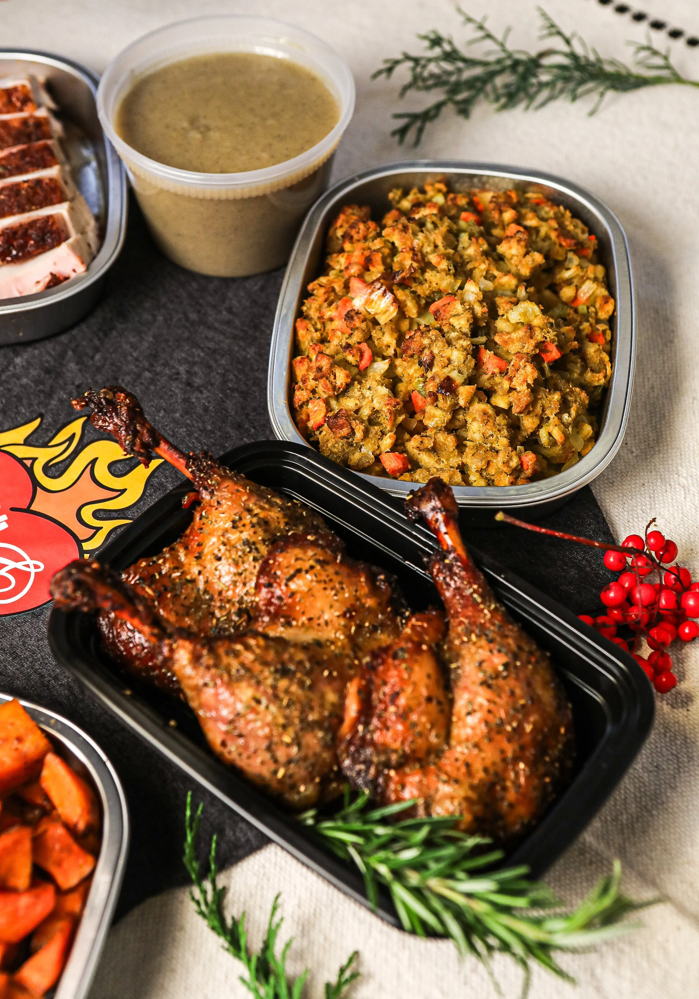 Roasted chicken, stuffing, green gravy, and roasted sweet potatoes on a table.
