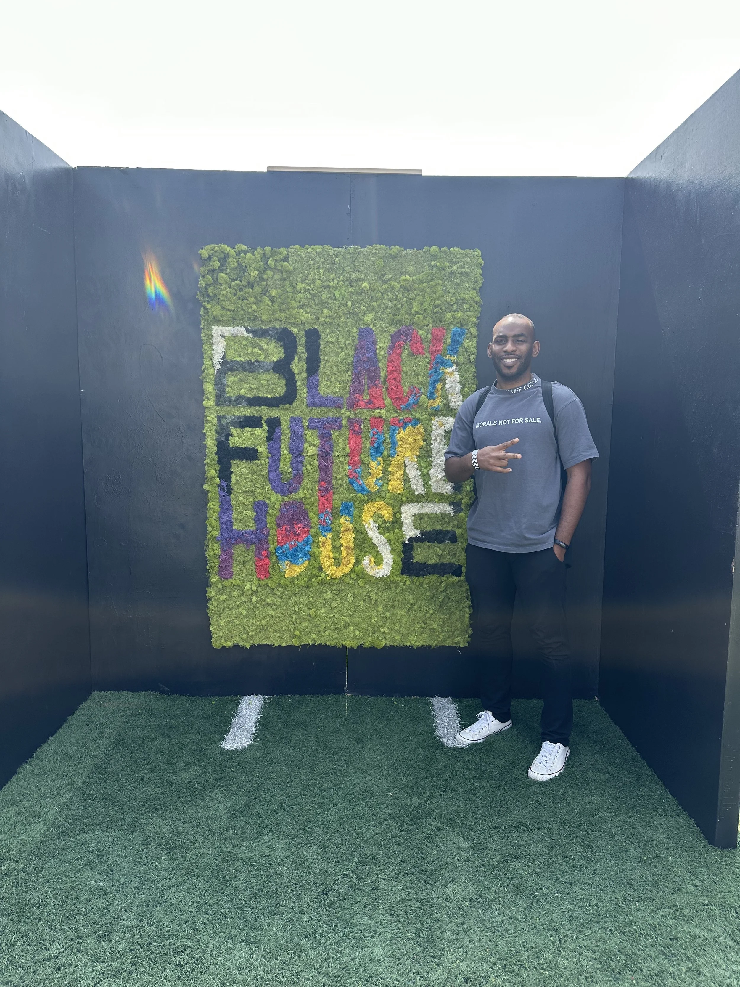 Amobi Okugo stands in front of a sign for "Black Future House" at SXSW.