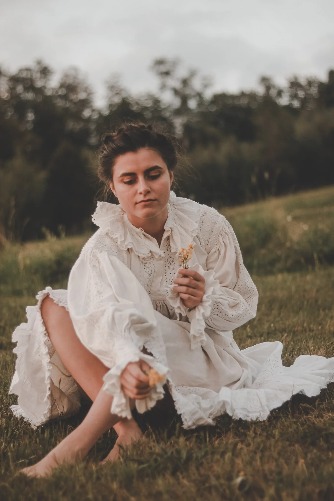 Young woman picking up flowers wearing romanian traditional clothes