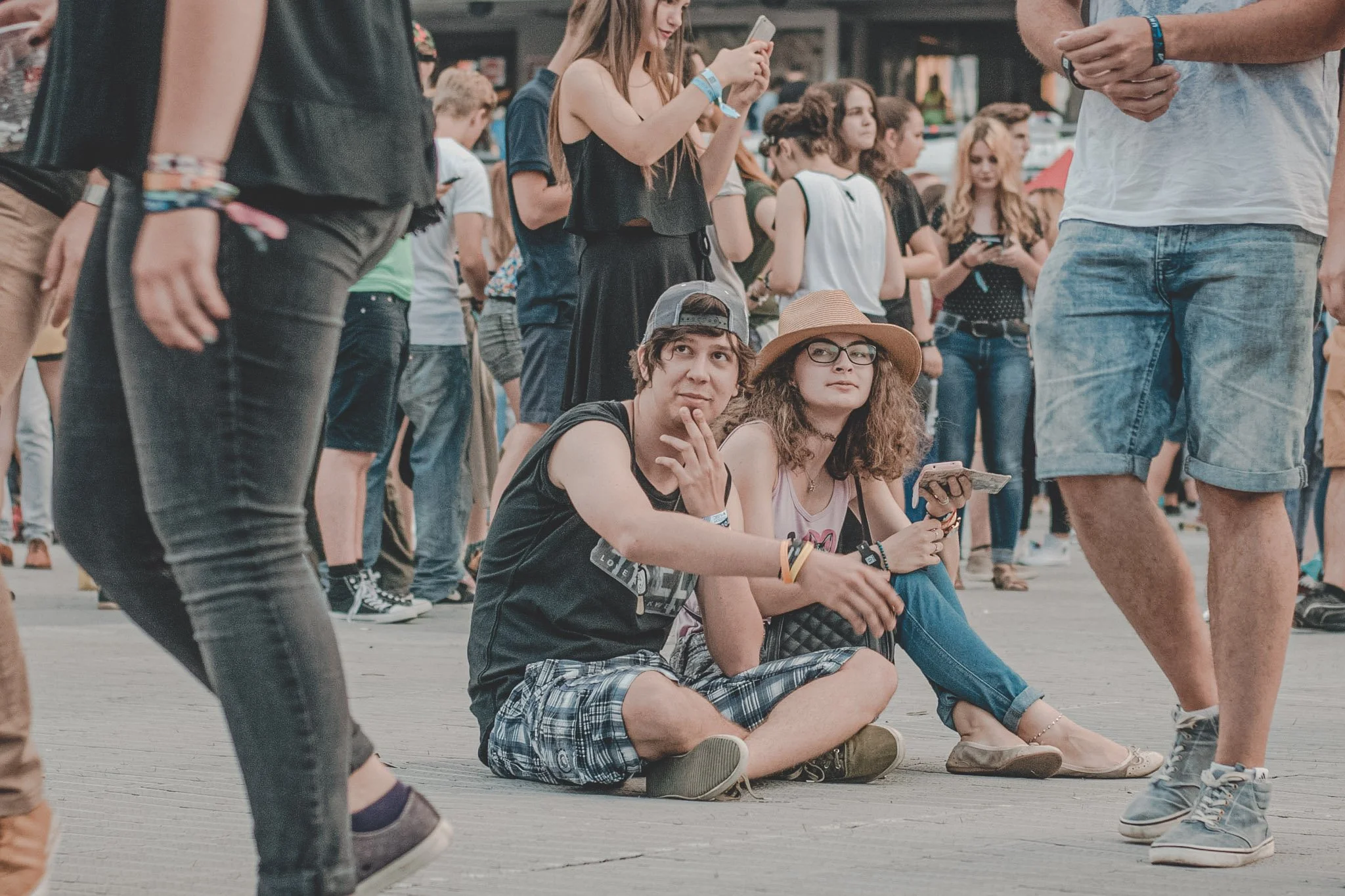 Boy and girl sitting on the floor waiting for the next dj at Untold Festival in Cluj-Napoca