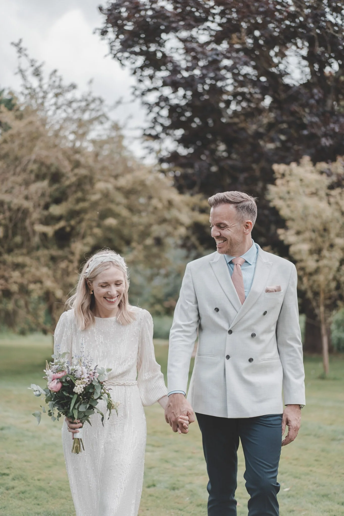 Newly weds walking together and holding hands on their wedding day at Friars Court, Oxfordshire, Wedding Venue