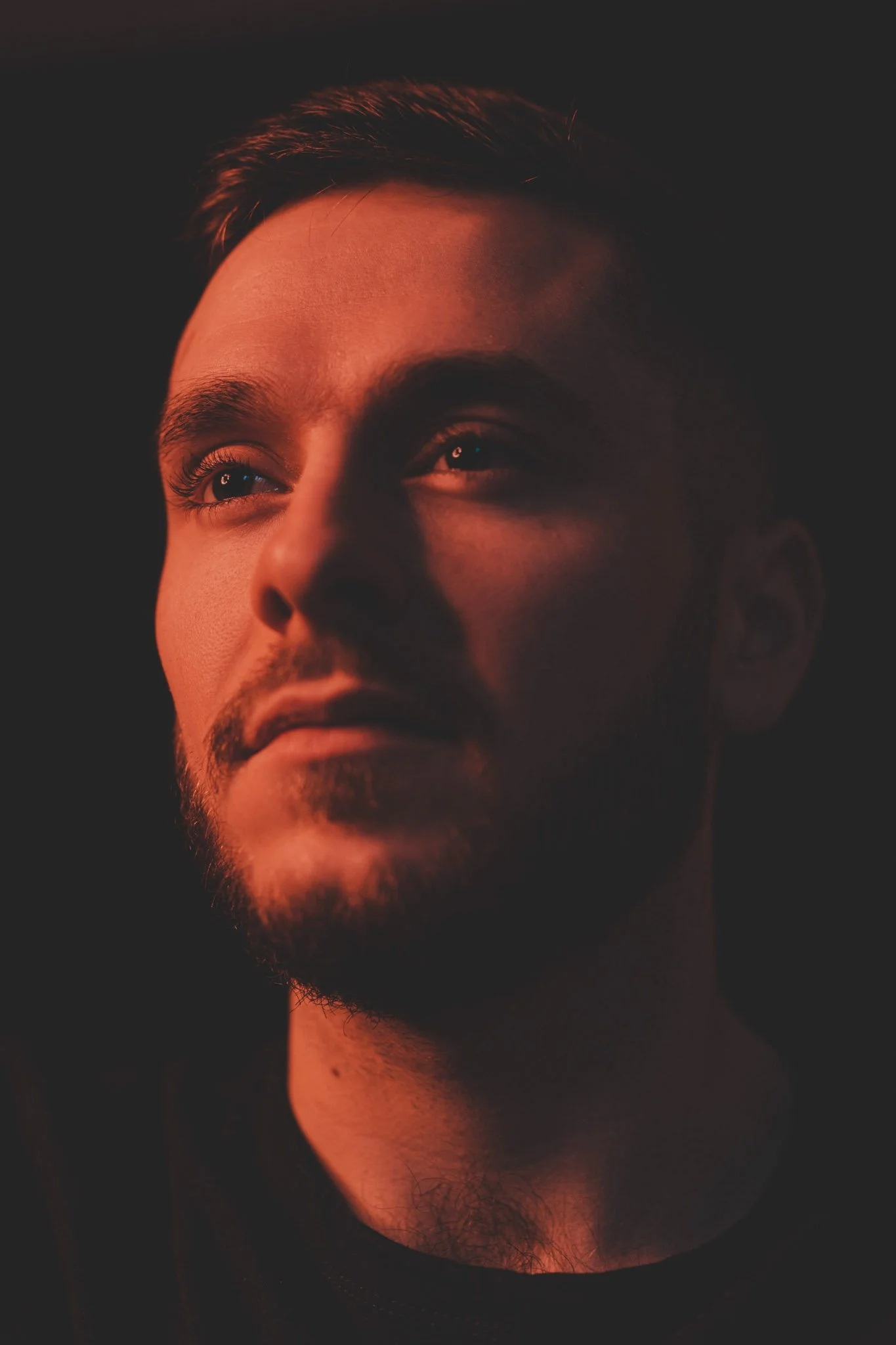 Portrait of a guy, looking away on a black background in Coventry photography studio