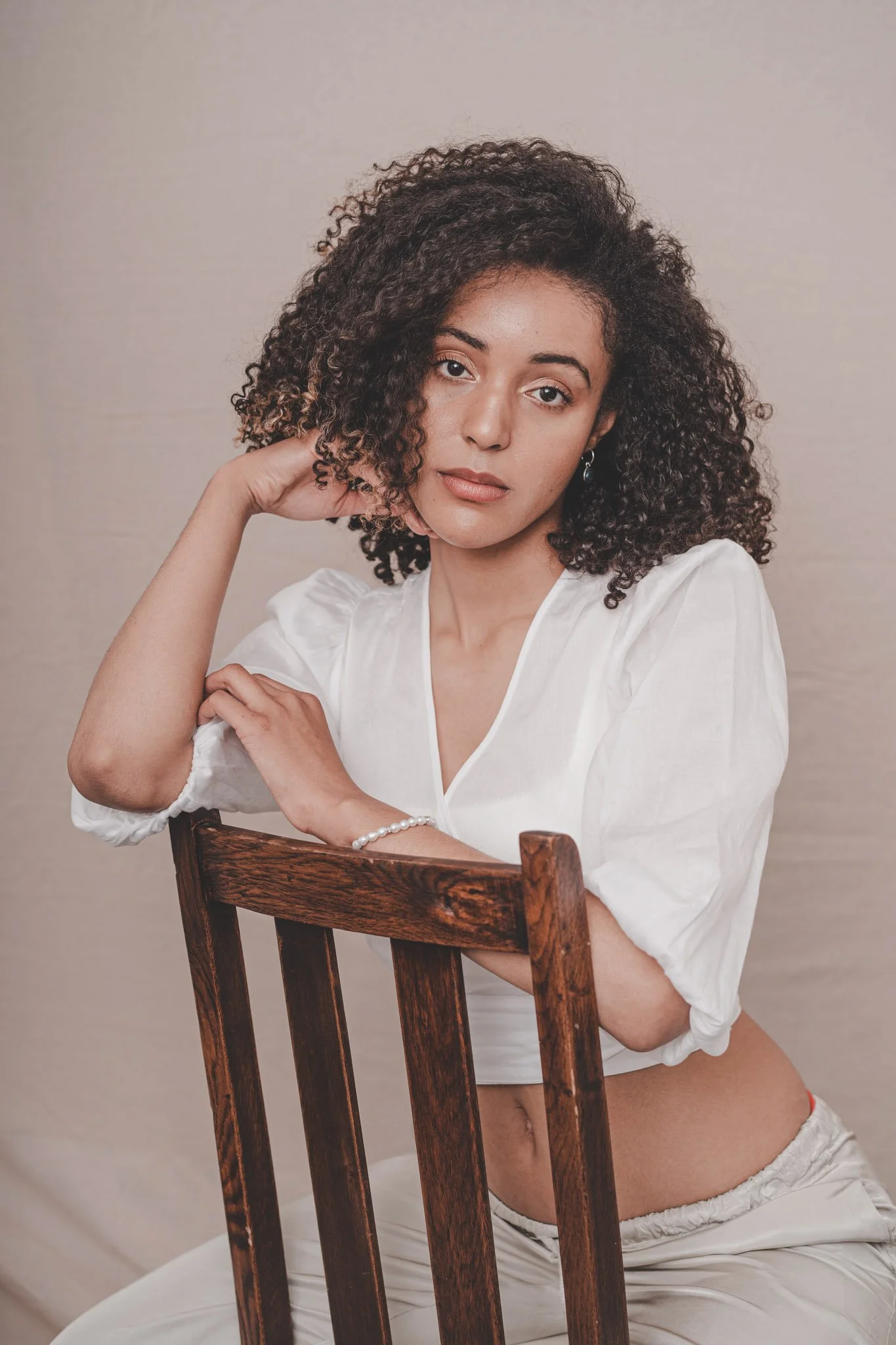 Girl wearing white looking at the camera at a studio portrait session in Coventry