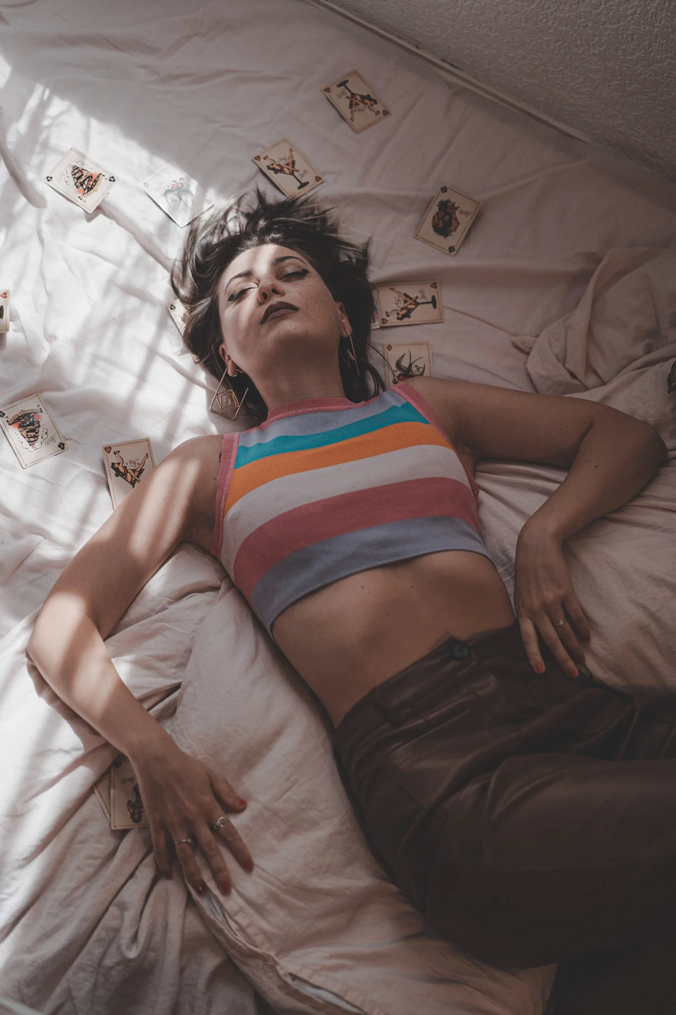 Girl laying on her back with a bunch of vintage poker cards around her 