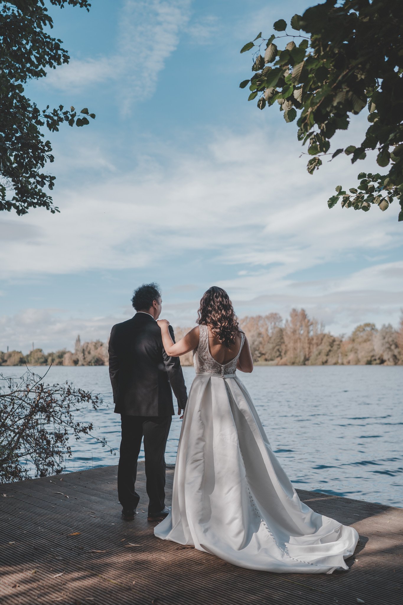 Bride and groom photographed from behind at Delapre Lake, Northampton