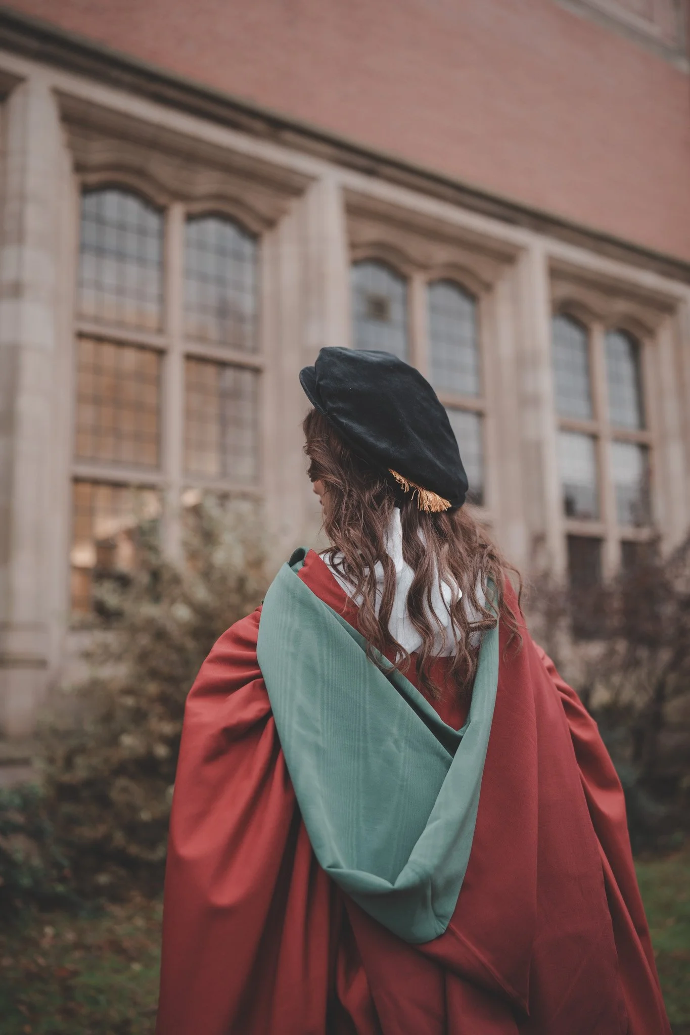 Girl with her back at the camera, wearing graduation clothes at Birmingham University