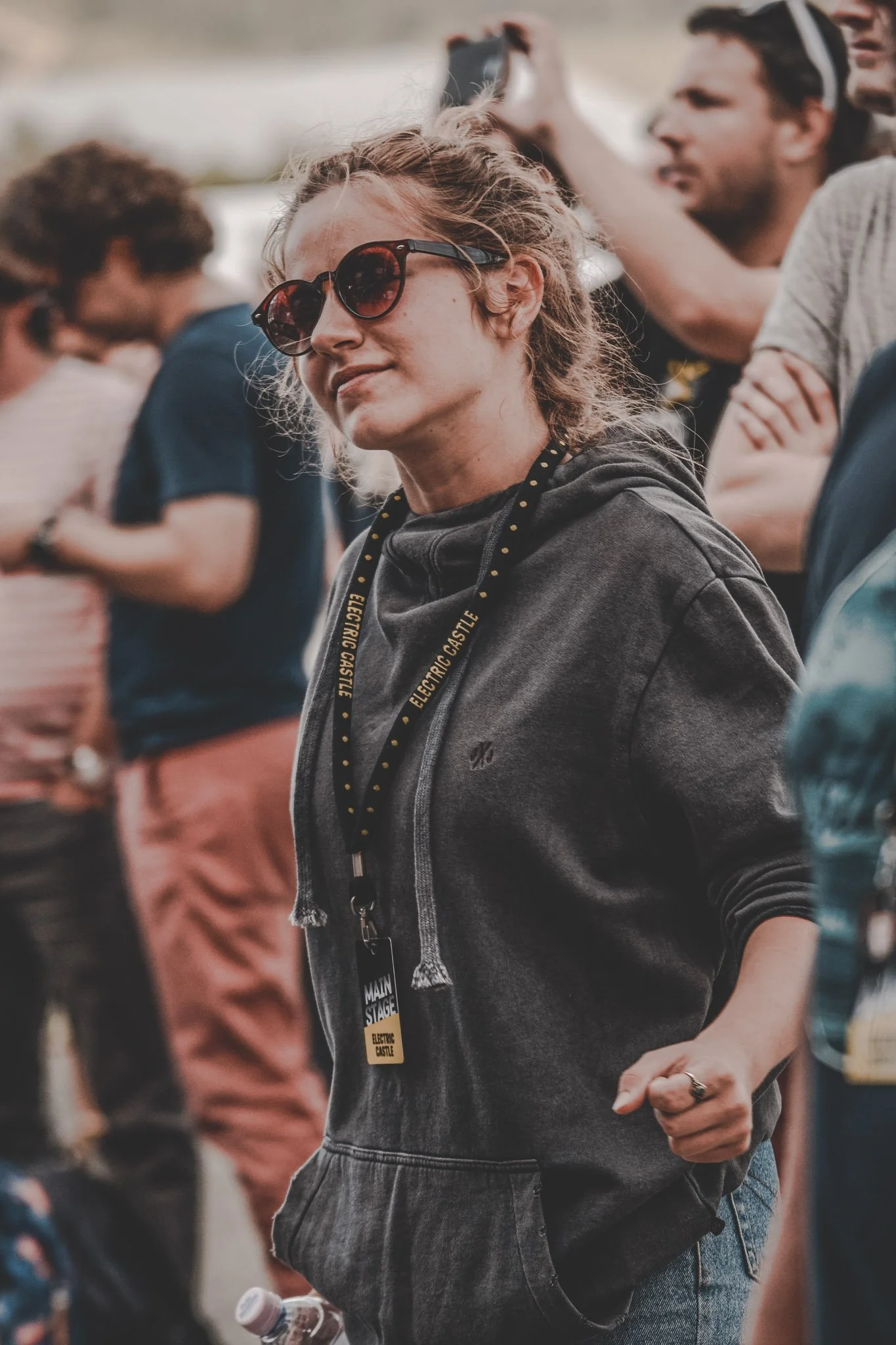 Girl wearing a hoodie and sunglasses dancing in the crowd at Electric Castle Festival