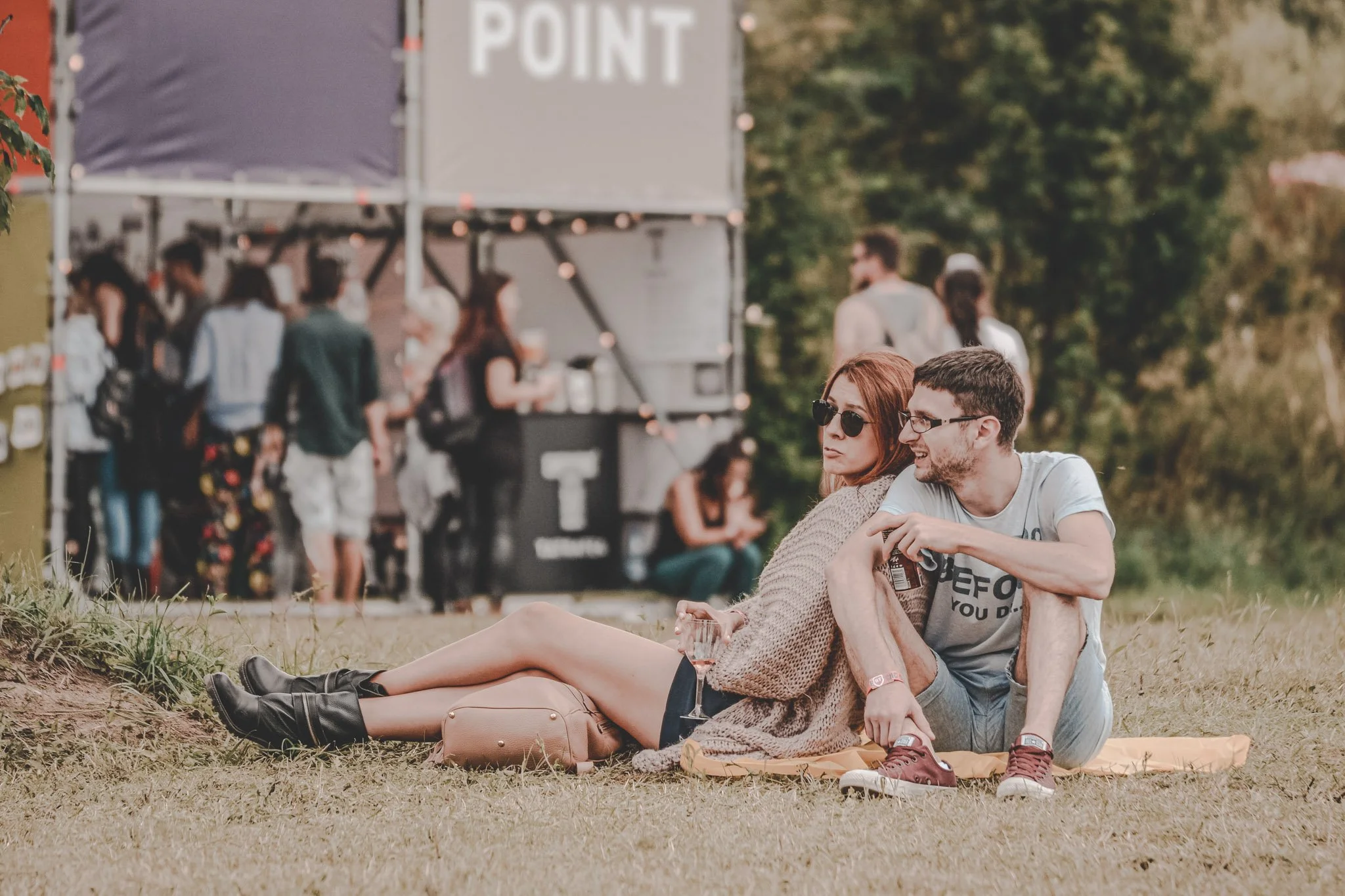 Couple photographed sitting together on the grass at Electric Castle Festival