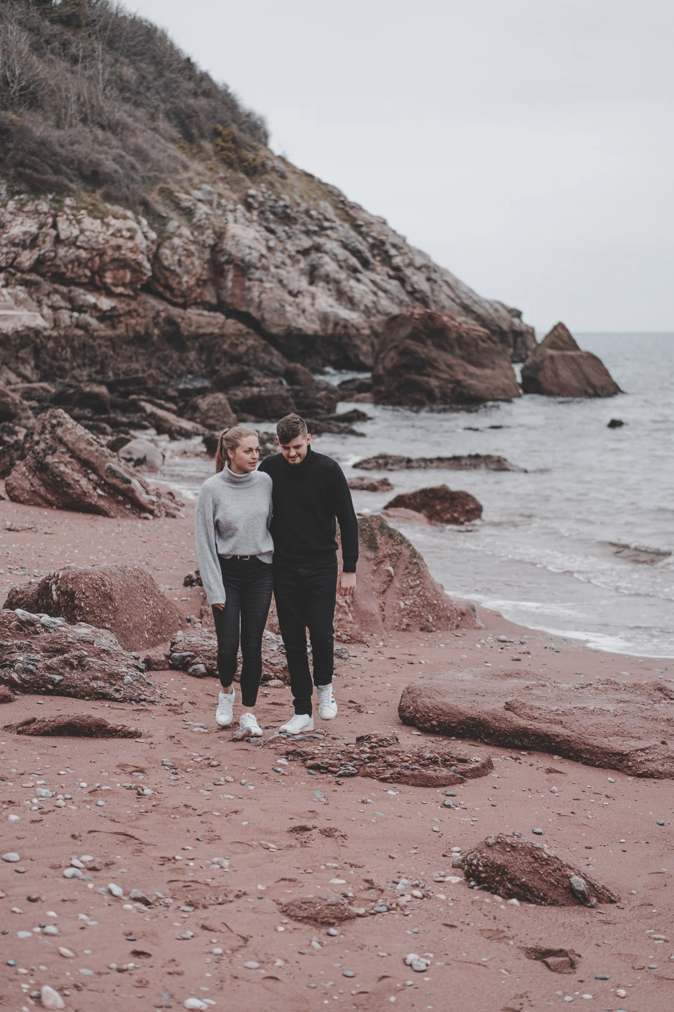 Boyfriend and girlfriend photographed walking together on Torquay beach