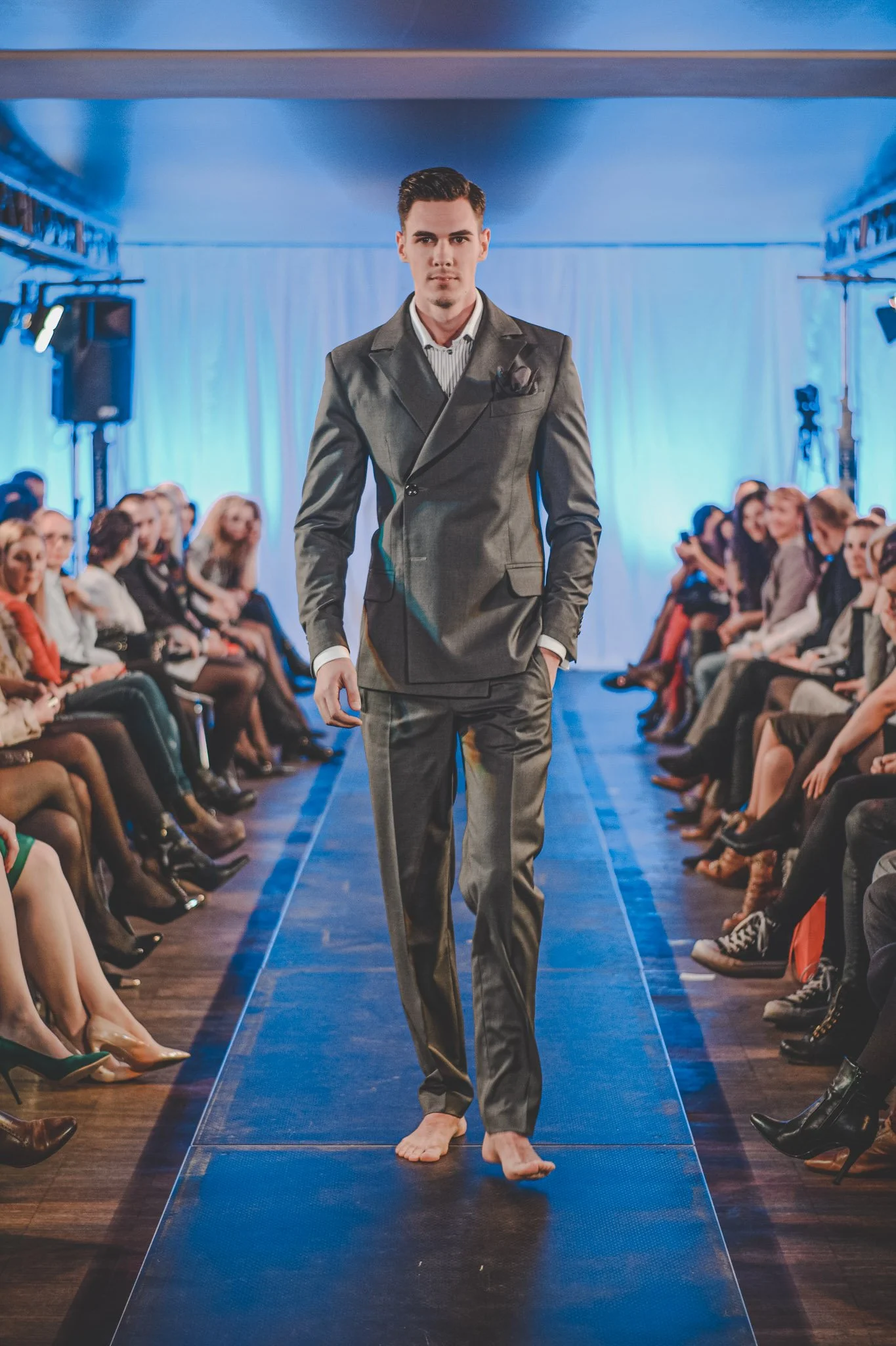Barefoot model wearing a costume walking on the stage at a fashion show in Romania