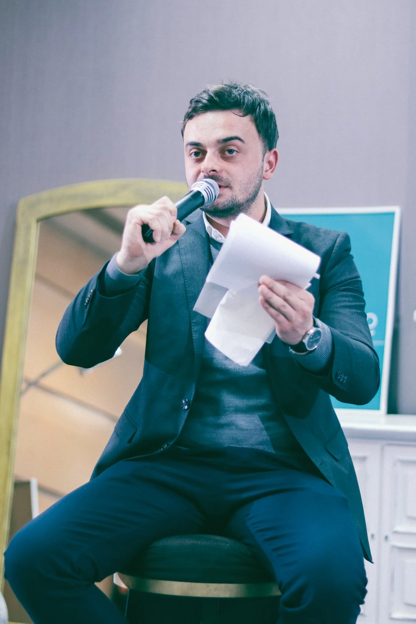 Man speaking to the public and holding a notebook