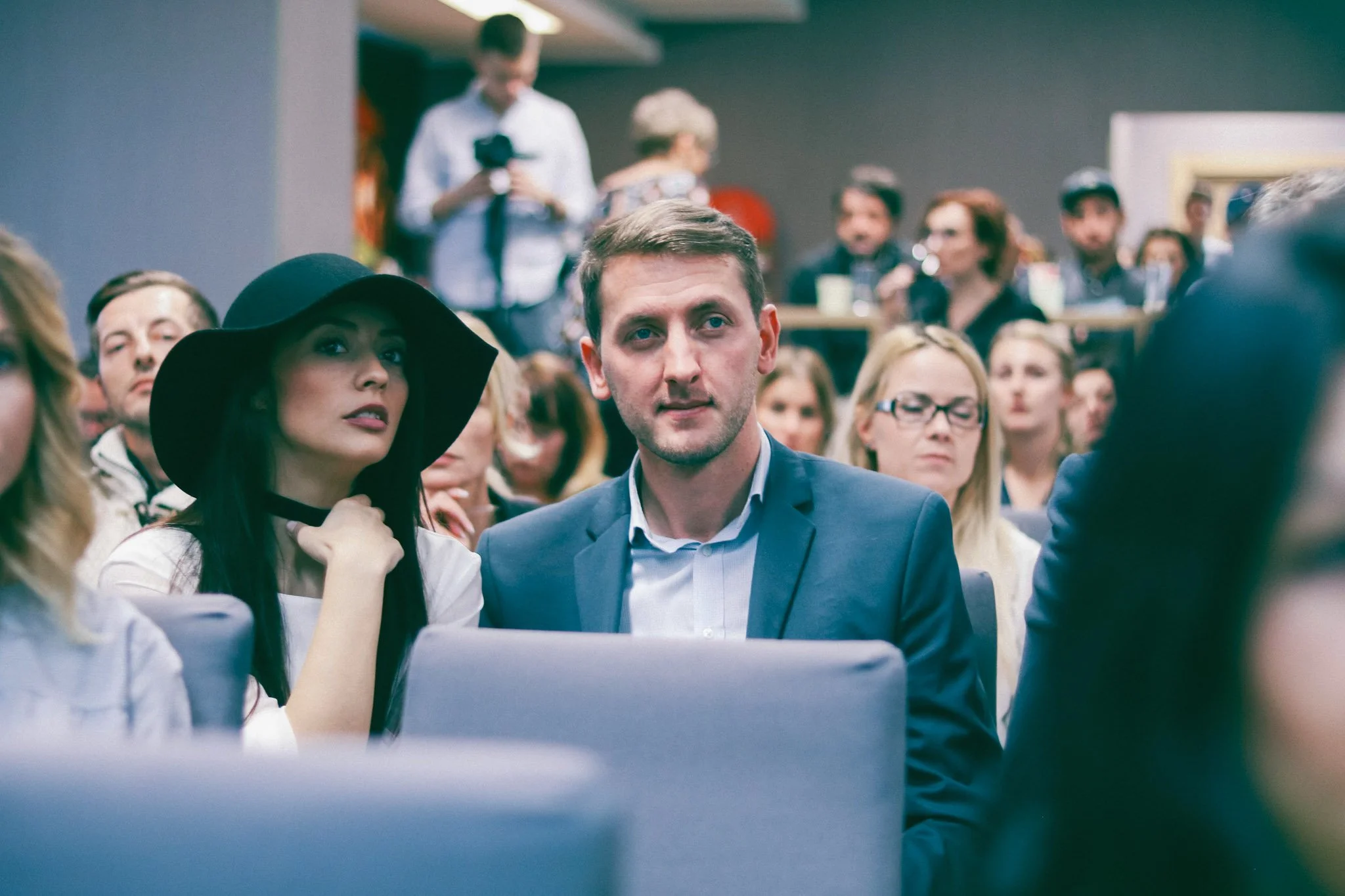 Man and woman photographed while paying attention to the speakers on stage at an event in Cluj-Napoca
