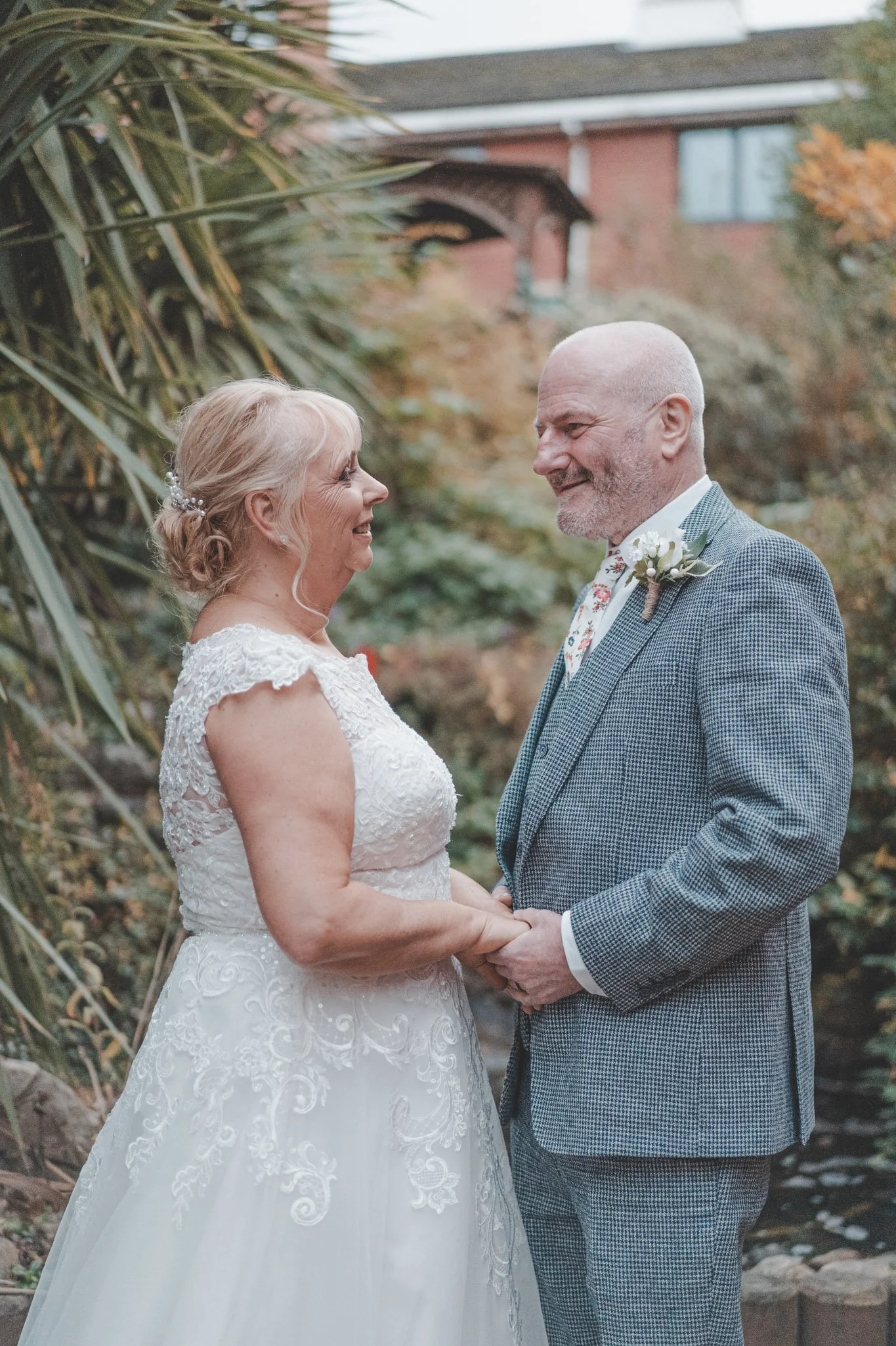 Bride and groom holding hands and looking at each other in Coventry