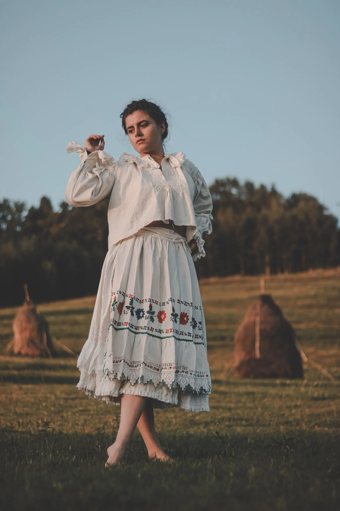 Girl dancing on a field wearing romanian traditional clothes