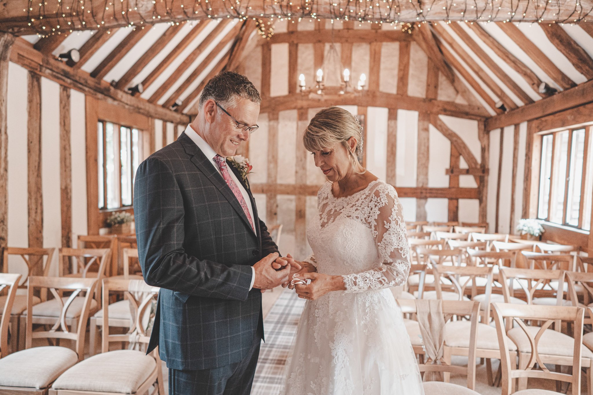 Bride and groom exchanging rings during their wedding ceremony at Cheylesmore Manor House, Coventry