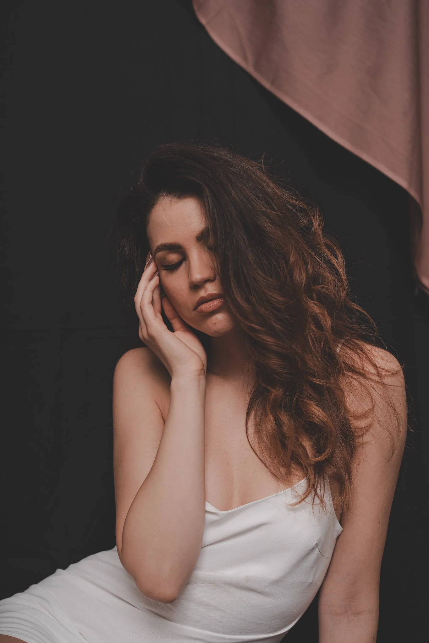 Girl with eyes closed wearing a white dress during a studio photography session in Coventry