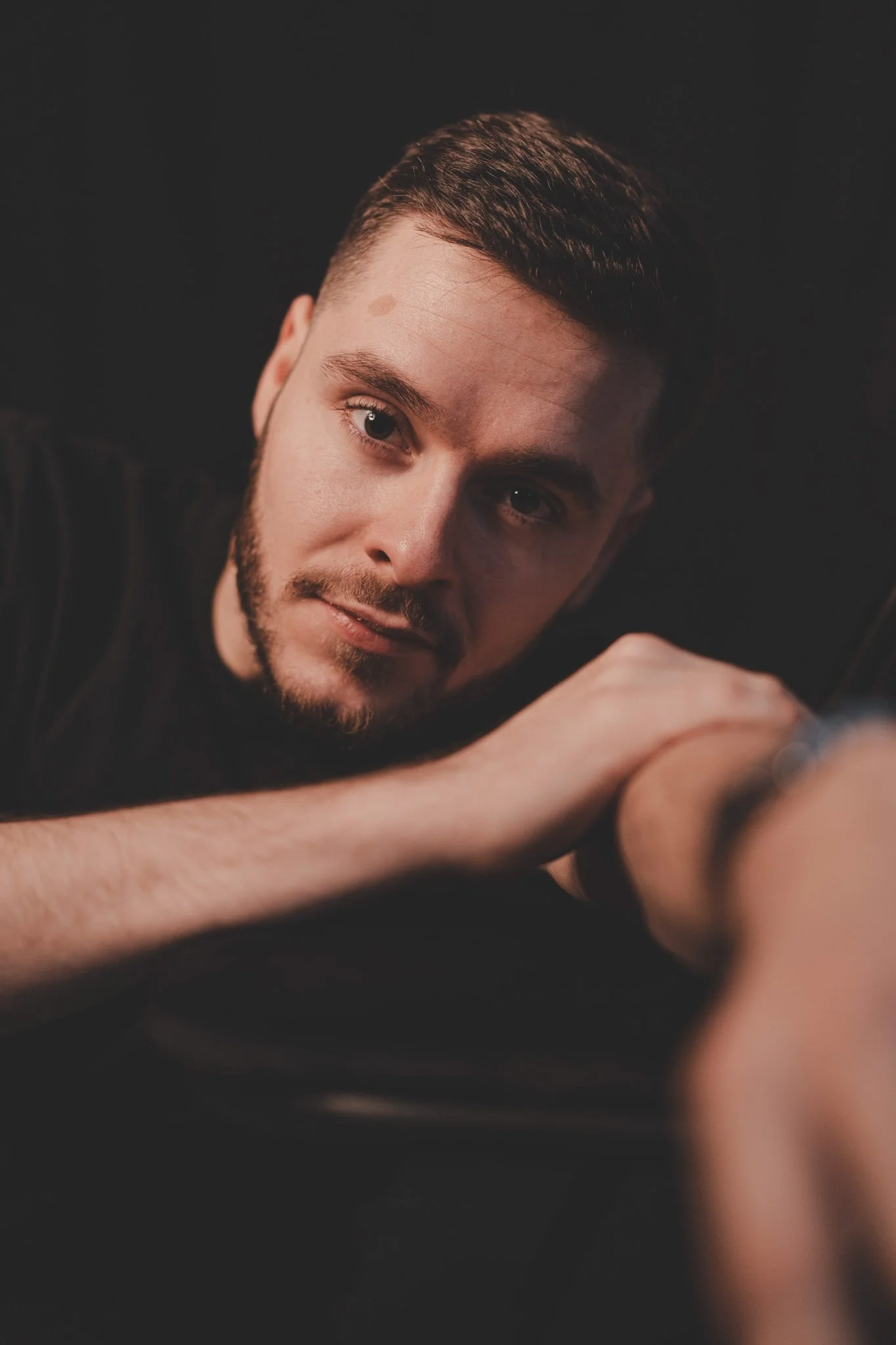 Guy looking straight at the camera in a studio with a black background in Coventry