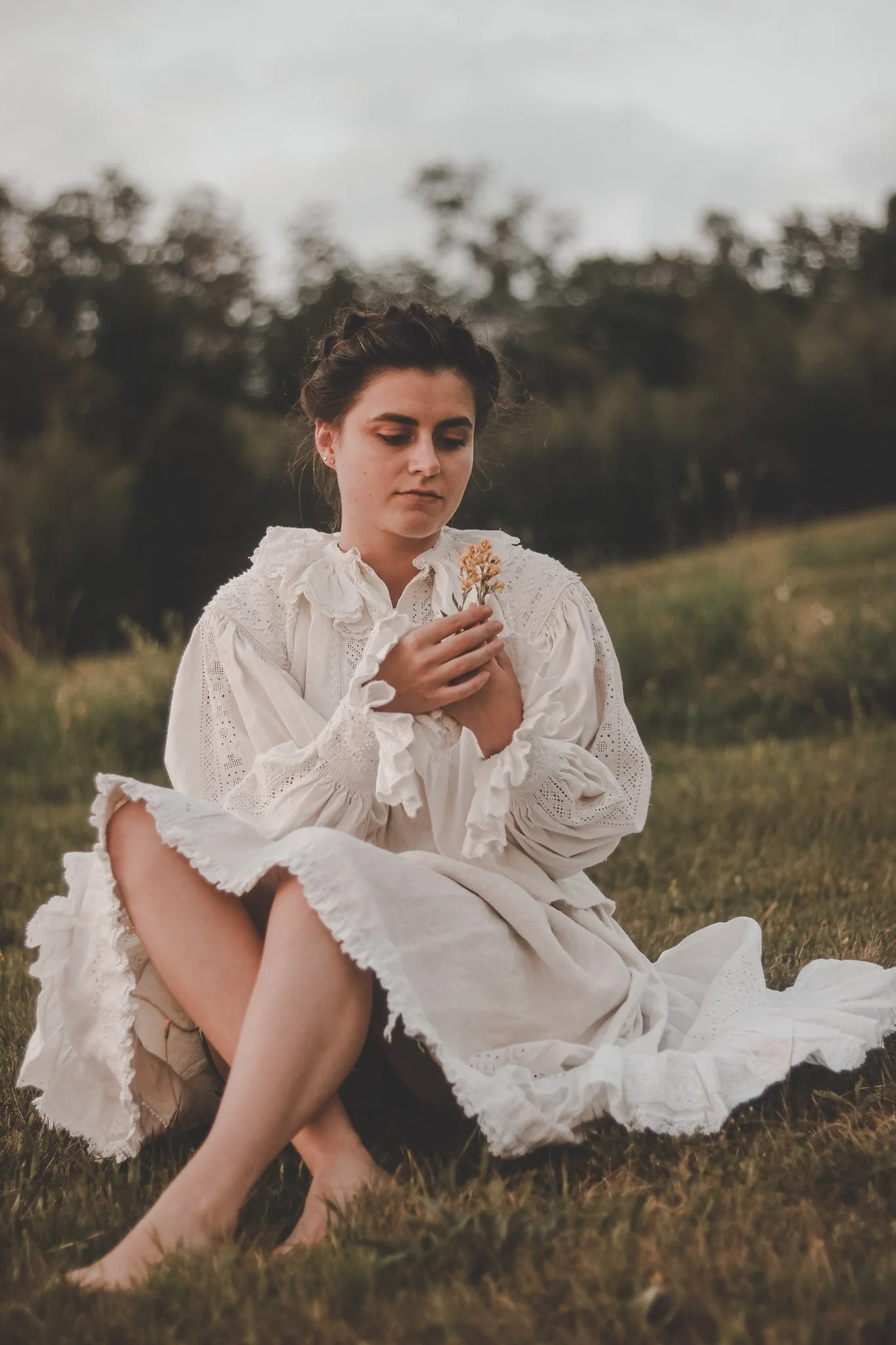 Young woman picking up flowers wearing romanian traditional clothes
