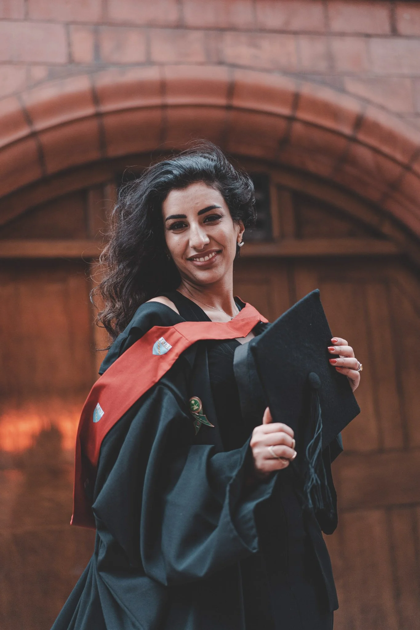 Girl smiling at the camera during her graduation photoshoot at Birmingham University