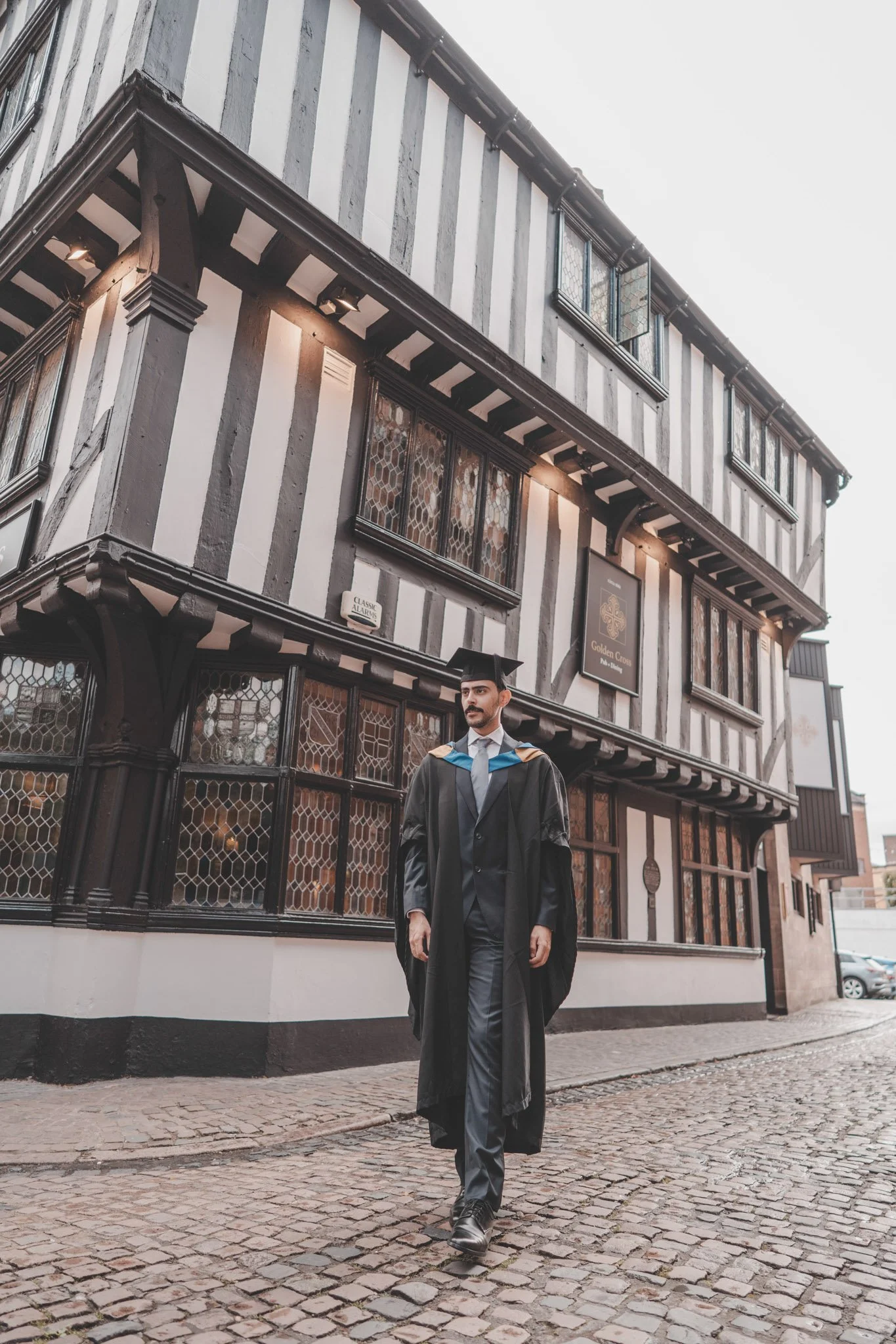 Man walking on his graduation day through Coventry city centre