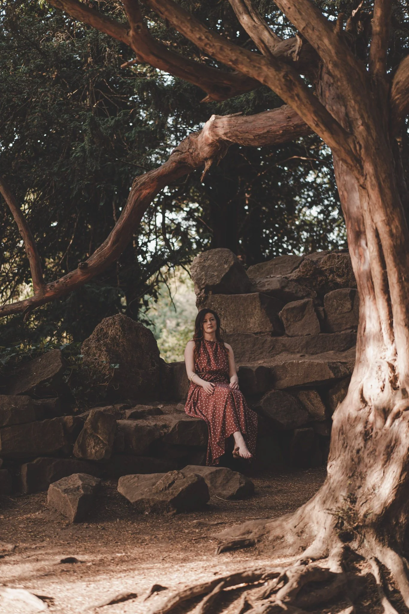 Woman in a red dress sitting under a tree