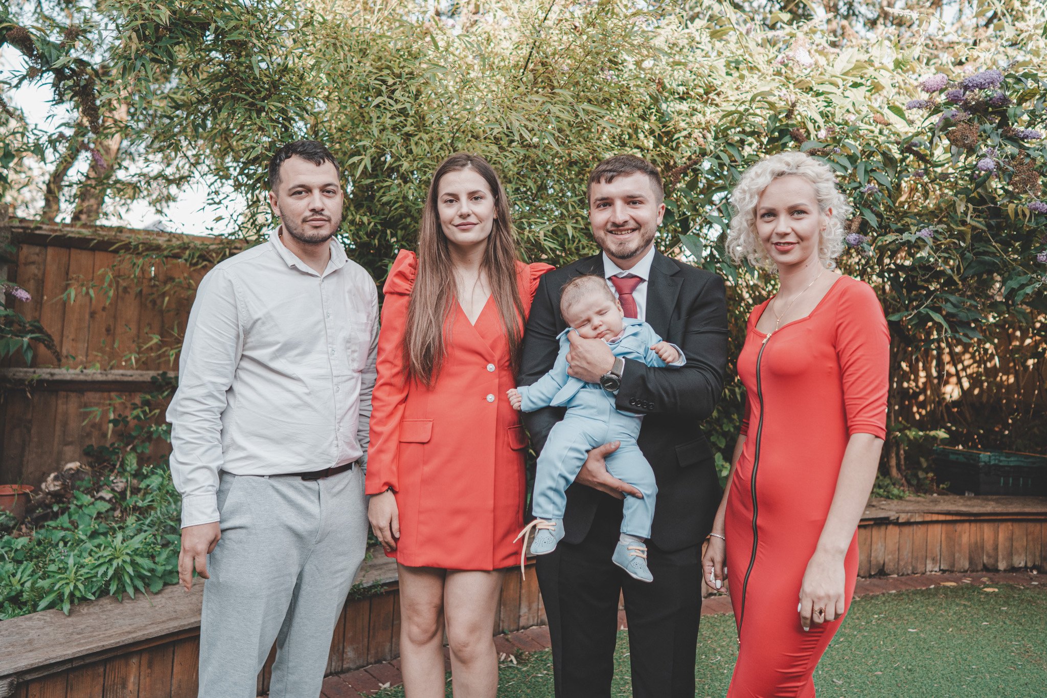 Group shot of parents holding a little boy, with their godparents 