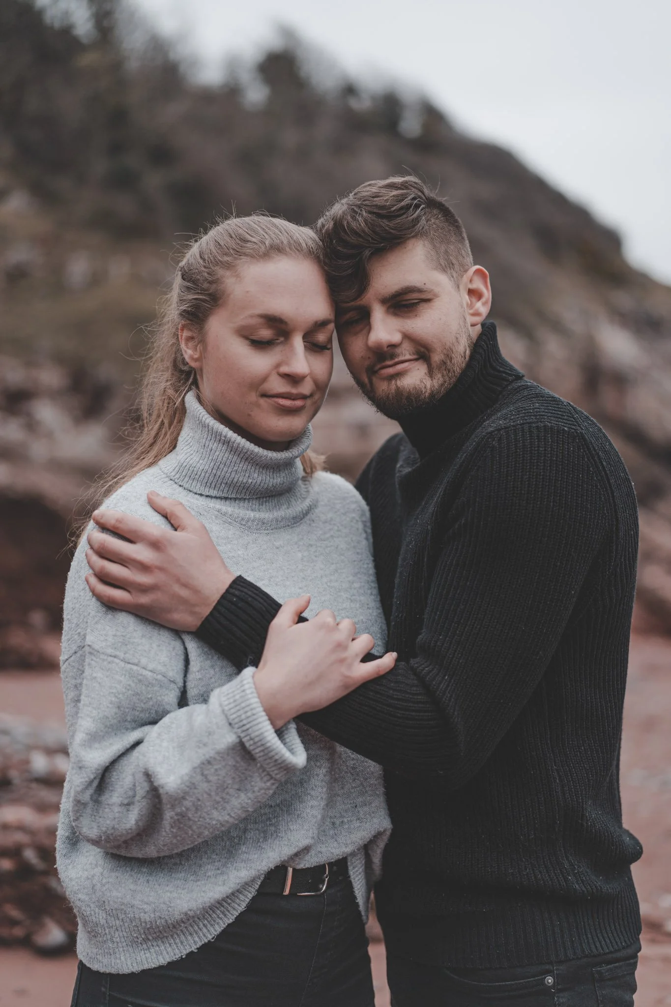 Girl and boy holding each other during a outdoor couple photoshoot in Cornwall, UK