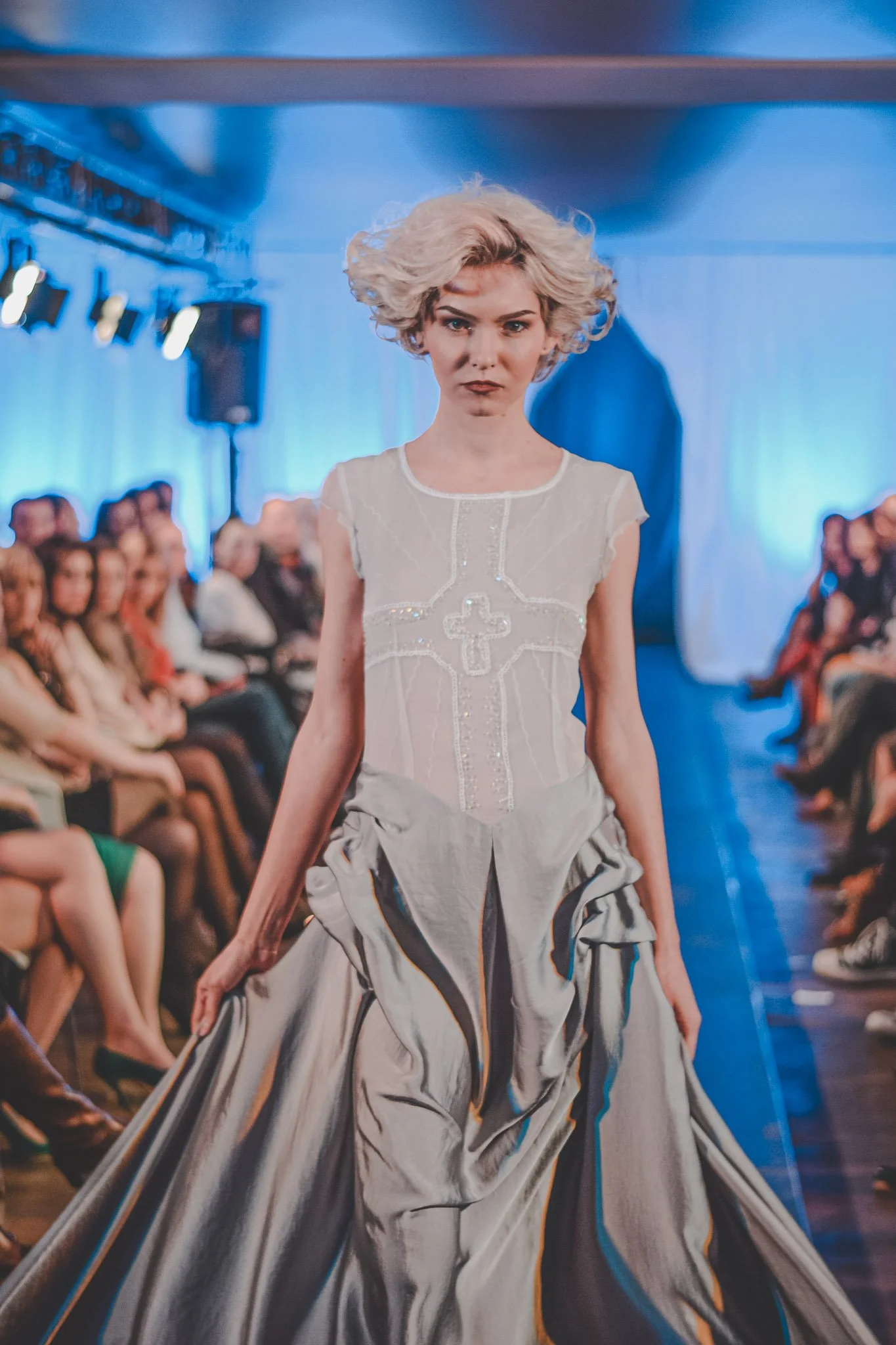 Girl wearing a grey dress photographed on stage at a fashion show in Romania