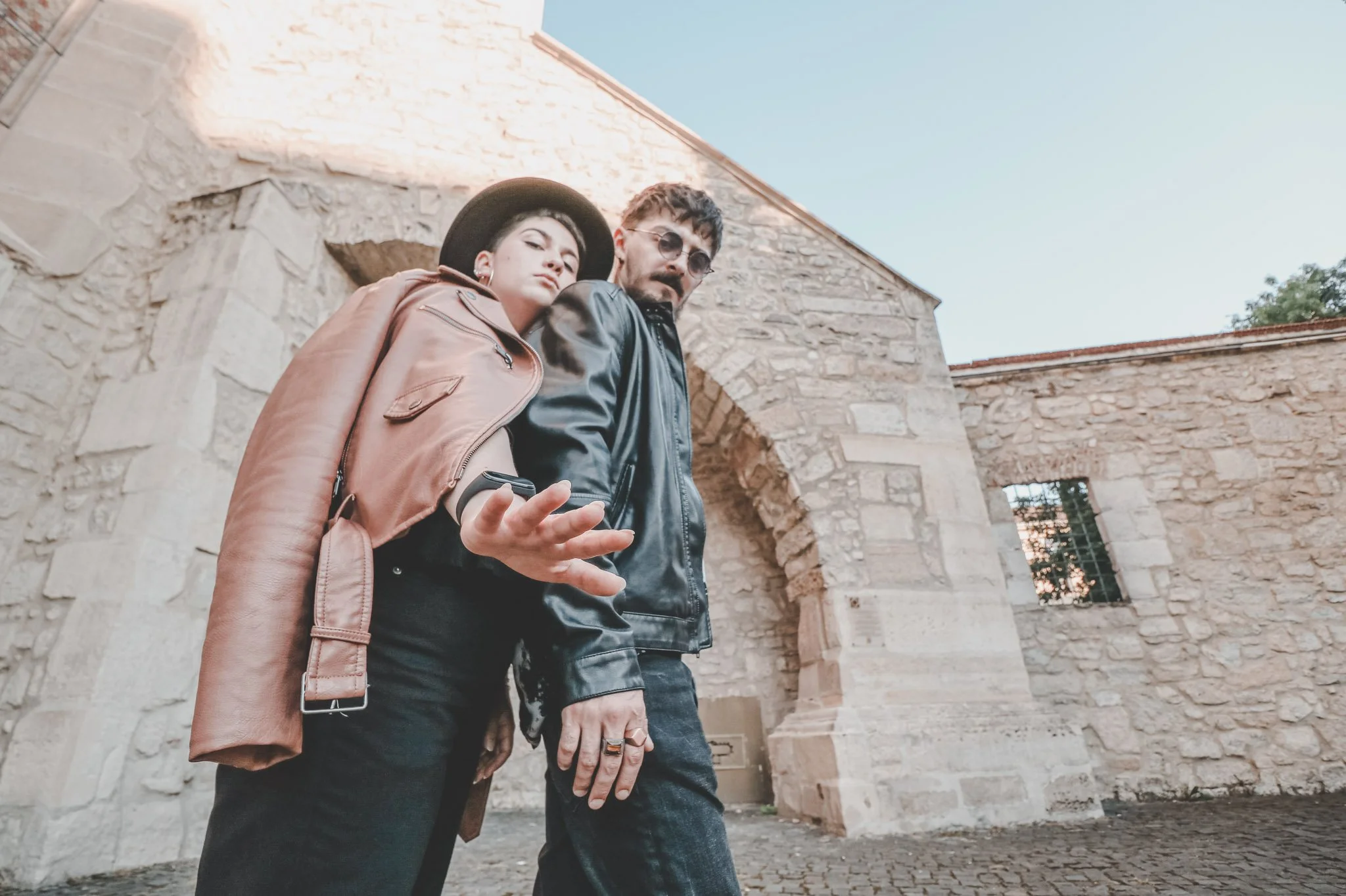 Couple photographed back to back in front of a gothic church on Mihail Kogălniceanu street in Cluj-Napoca