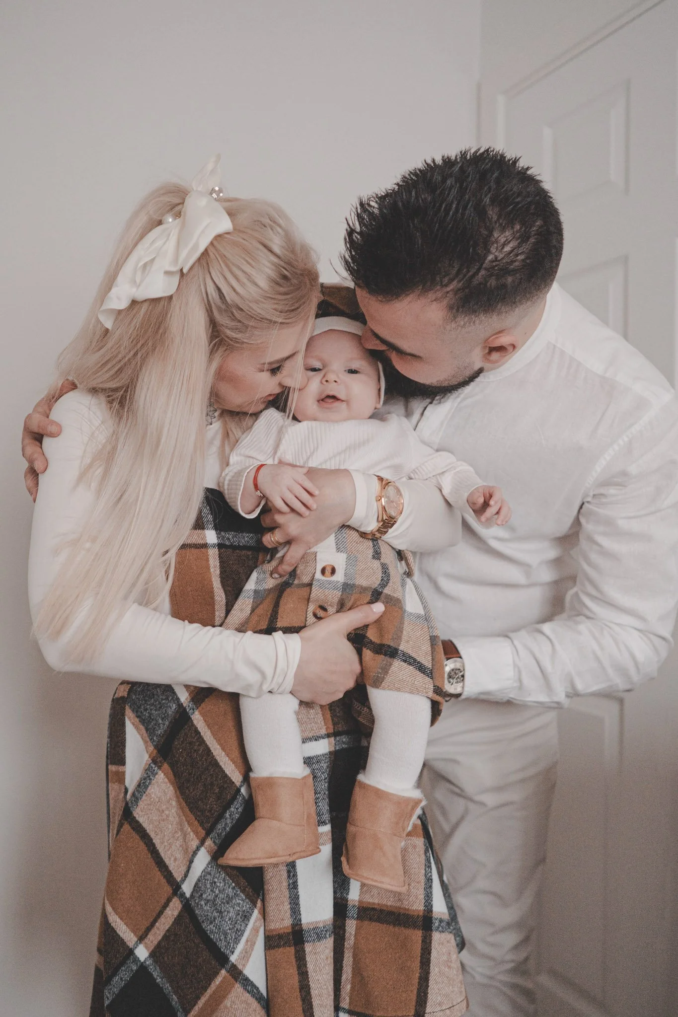 Parents holding their daughter and kissing her