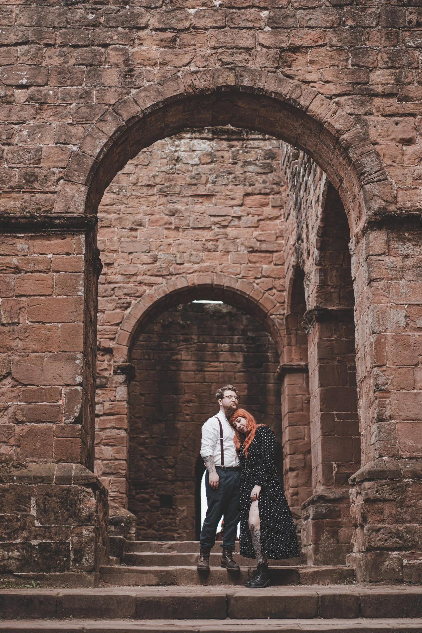 Boyfriend and girlfriend photographed from afar while holding each other at Kenilworth Castle 