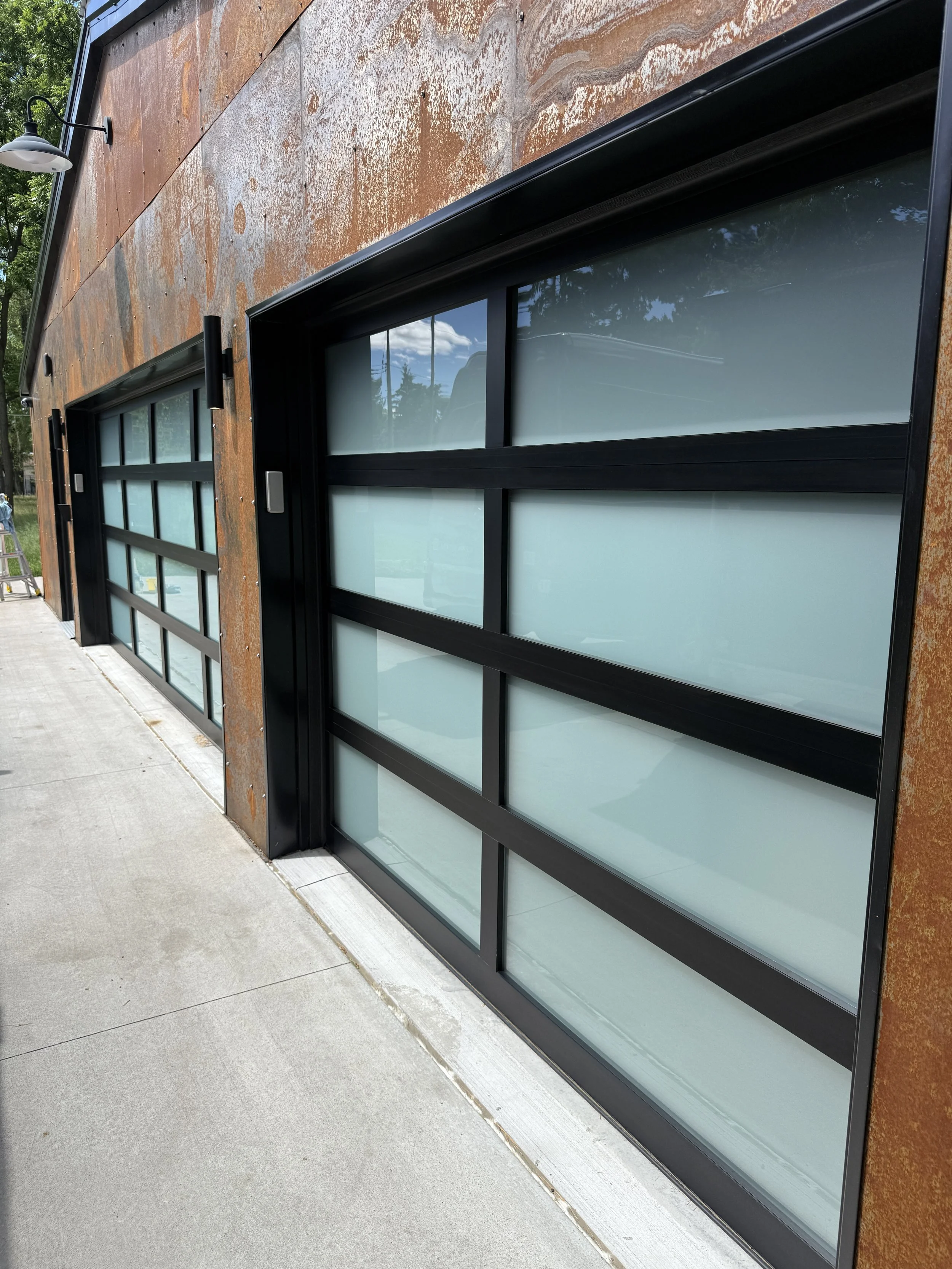 Close-up of a modern building's exterior with cleaned large glass garage doors.