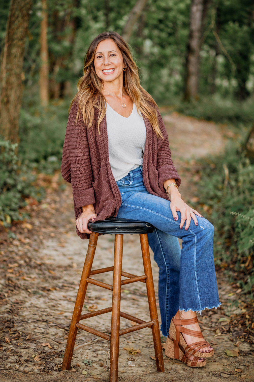 Health coach sitting outdoors in a peaceful wooded setting.