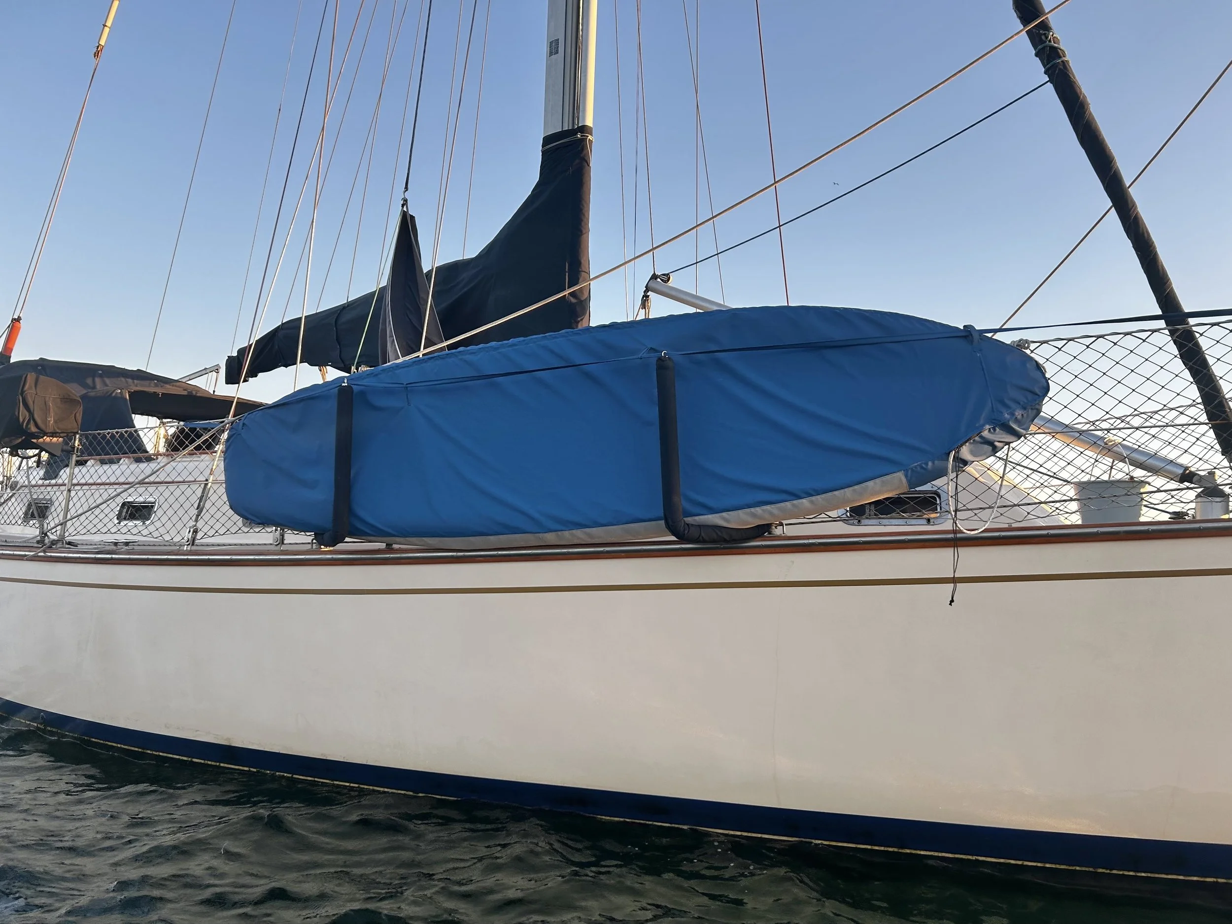 SUP cover for UV protection with Phifertex bottom for drainage and extended strap to prevent headsail sheets from catching