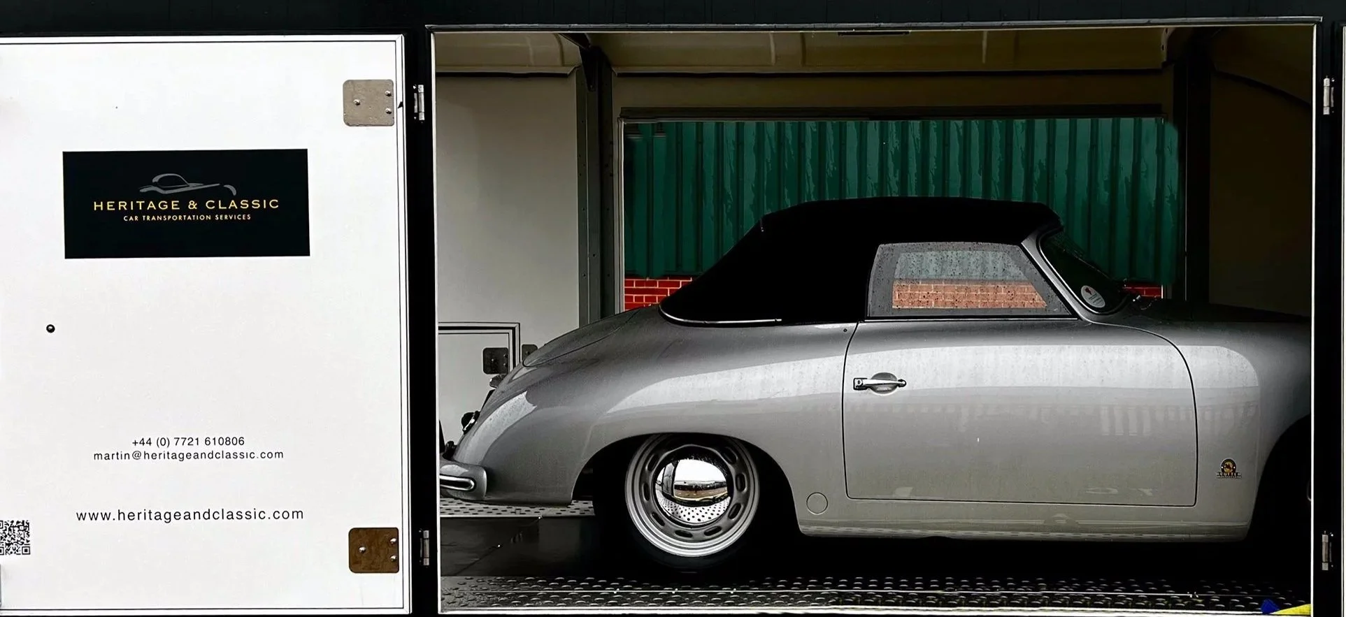 Silver Porsche 356 inside a trailer with Heritage & Classic Car Transportation branding, offering services like vehicle inspection, tracking, and insurance.