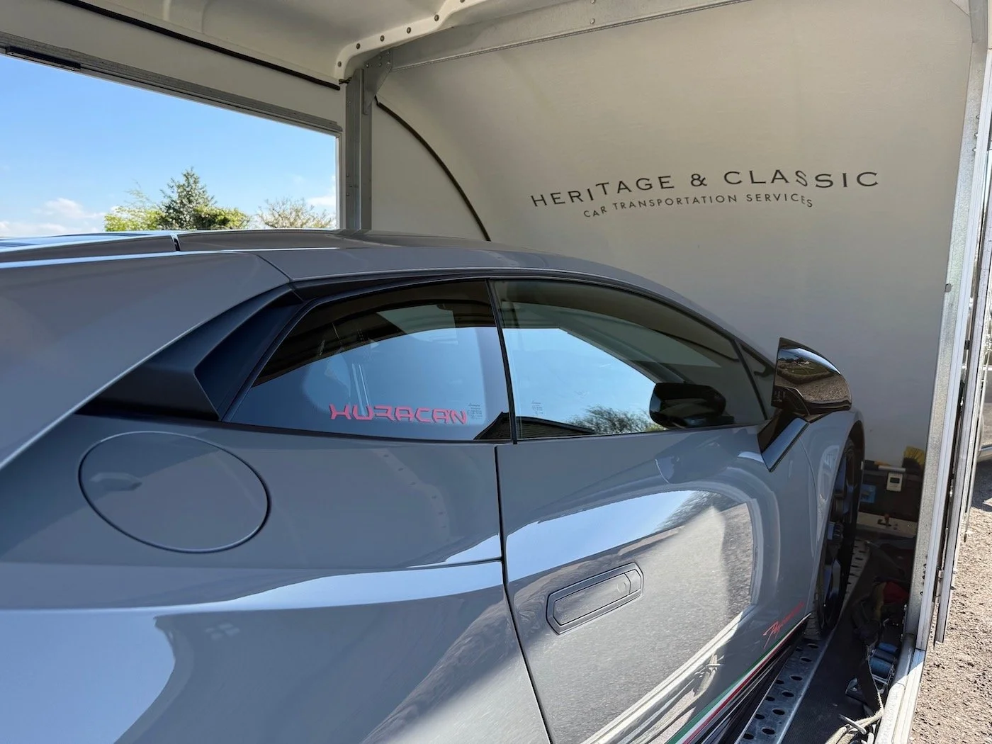 A Lamborghini Huracán loaded gently into an enclosed tilting-body trailer by Heritage and Classic for specialist supercar transport.