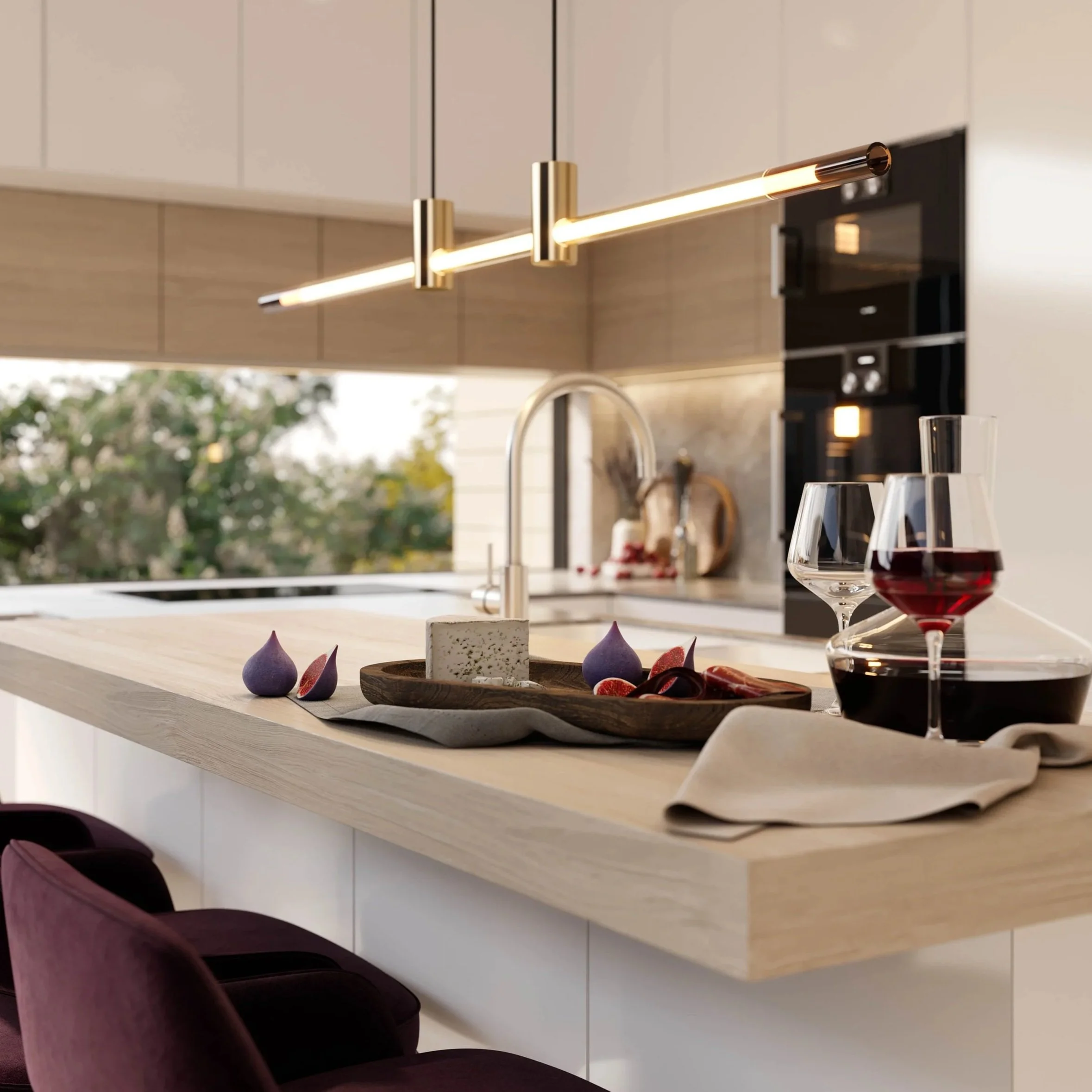 Modern kitchen interior with pendant lights, a white countertop, wine glasses, and a wooden serving tray with cheese and grapes.