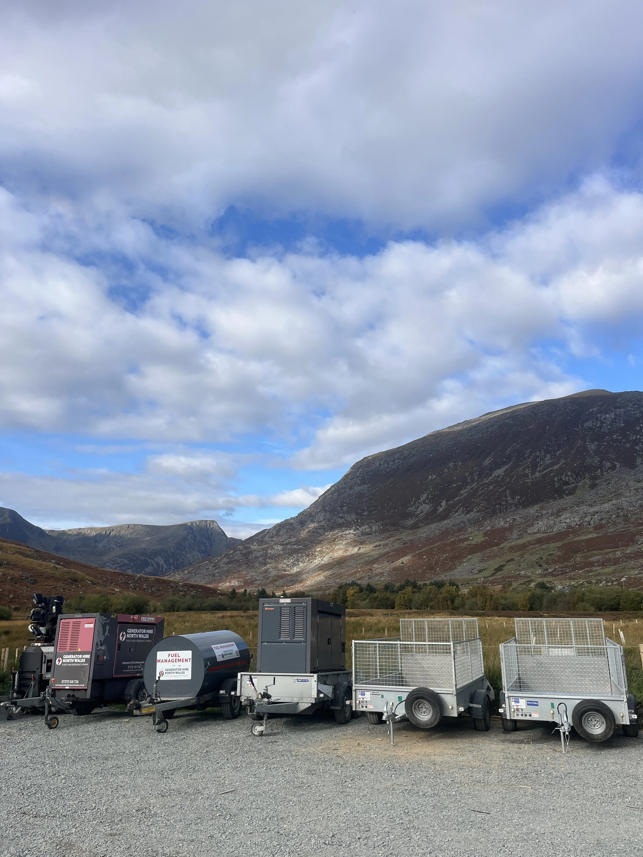 Nighttime outdoor scene with two blue water tanks on a trailer, labeled 'F02' and 'F01', and industrial equipment nearby.