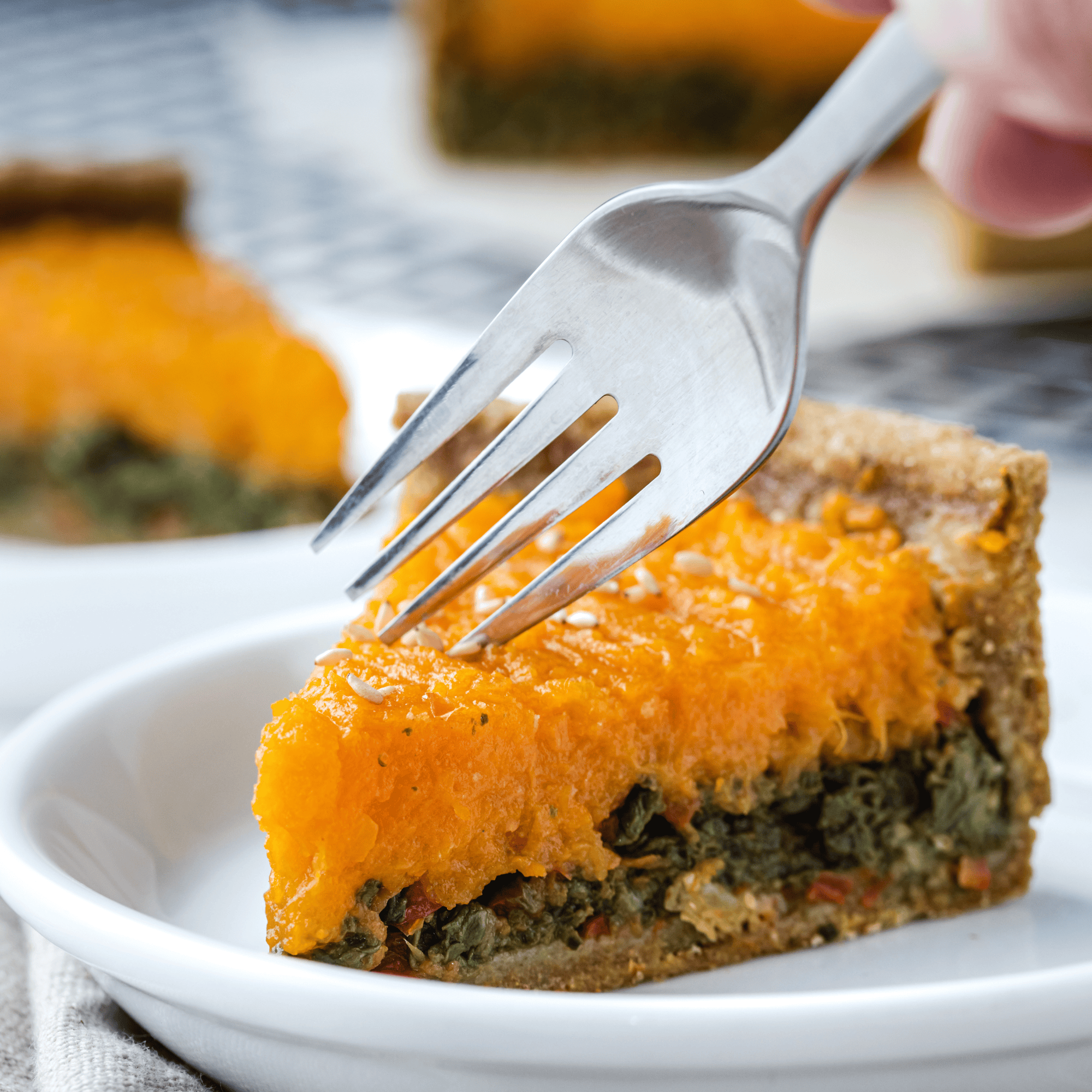 Part de tarte à la courge butternut et blettes servie dans une assiette