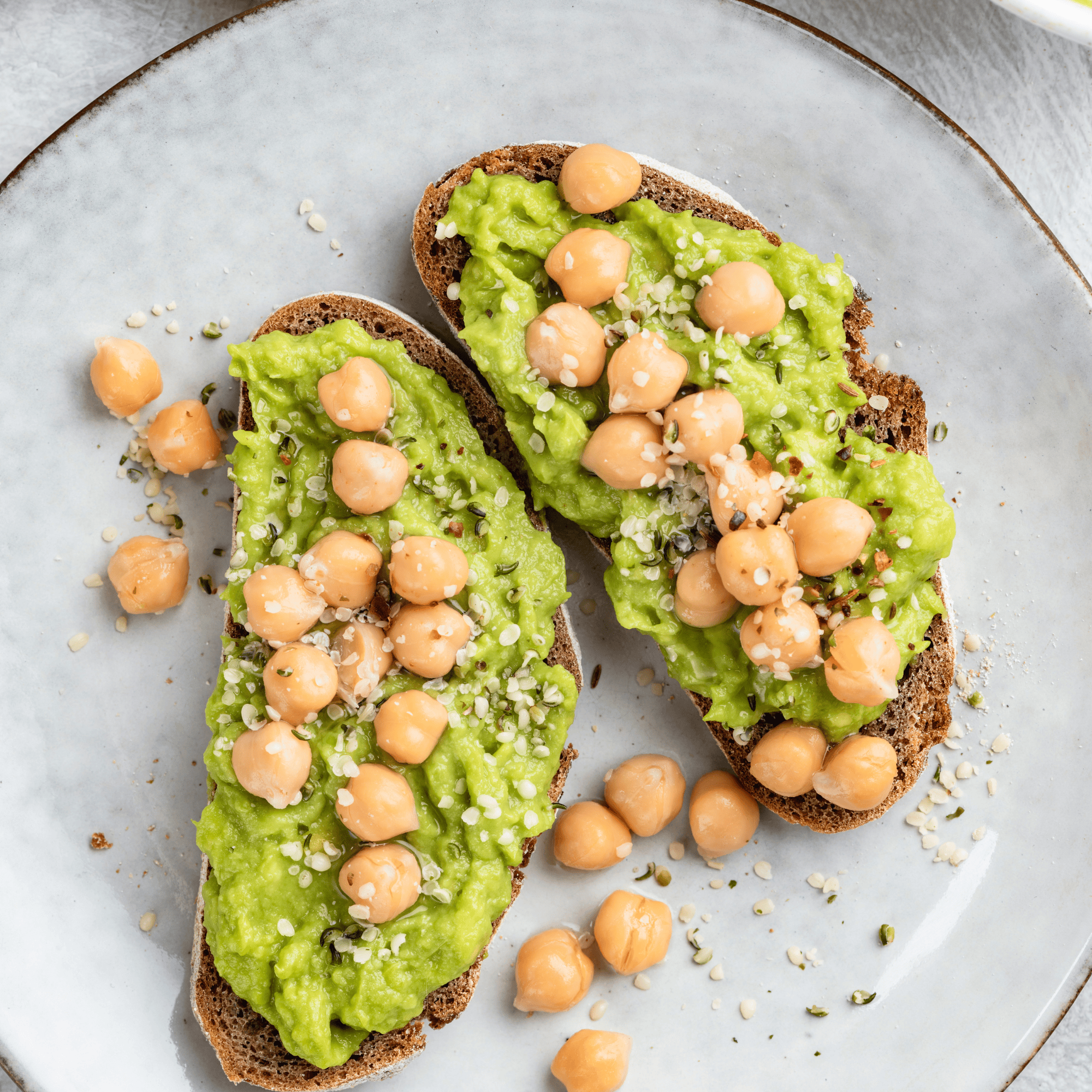 Tartines de pain complet à l’avocat écrasé, pois chiches et graines de chanvre