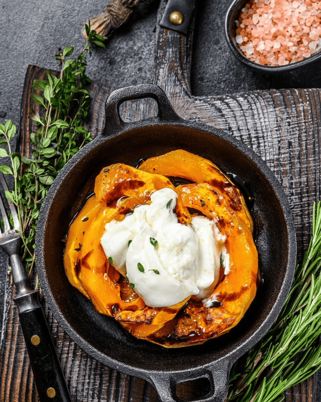 Plat rustique avec quartiers de courge rôtie au four, burrata fondue au centre, filet de balsamique et thym frais